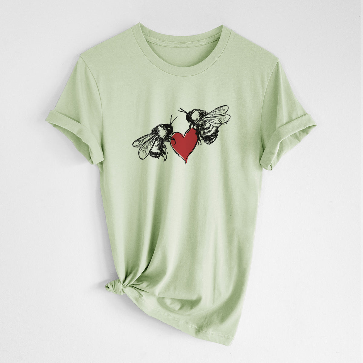 Spring green lightweight cotton t-shirt laid flat with the sleeves rolled, printed with a black ink illustration of two bees facing each other with a red heart between them.