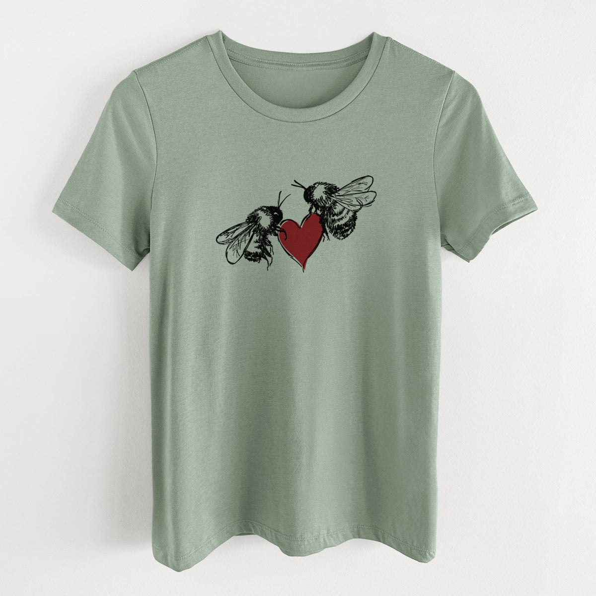 Sage green women's relaxed fit cotton t-shirt laid flat, printed with a black ink illustration of two bees facing each other with a red heart between them.