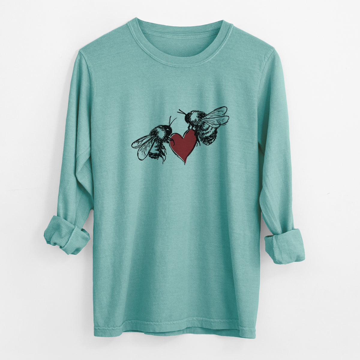 Reef green Comfort Colors long sleeve shirt laid flat with the cuffs rolled, printed with a black ink illustration of two bees facing each other with a red heart between them.
