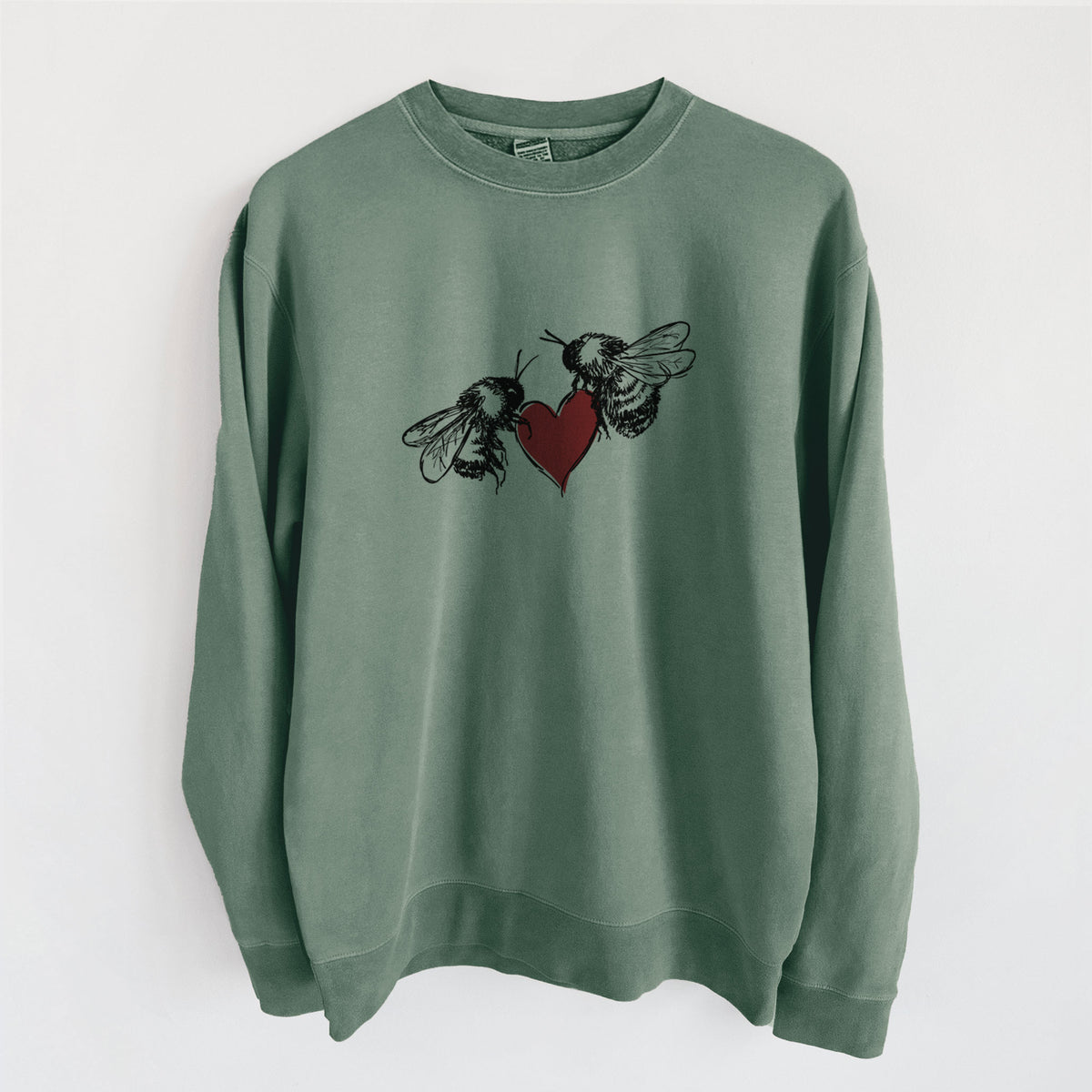 Alpine green pigment dyed crewneck sweatshirt laid flat, printed with a black ink illustration of two bees facing each other with a red heart between them.