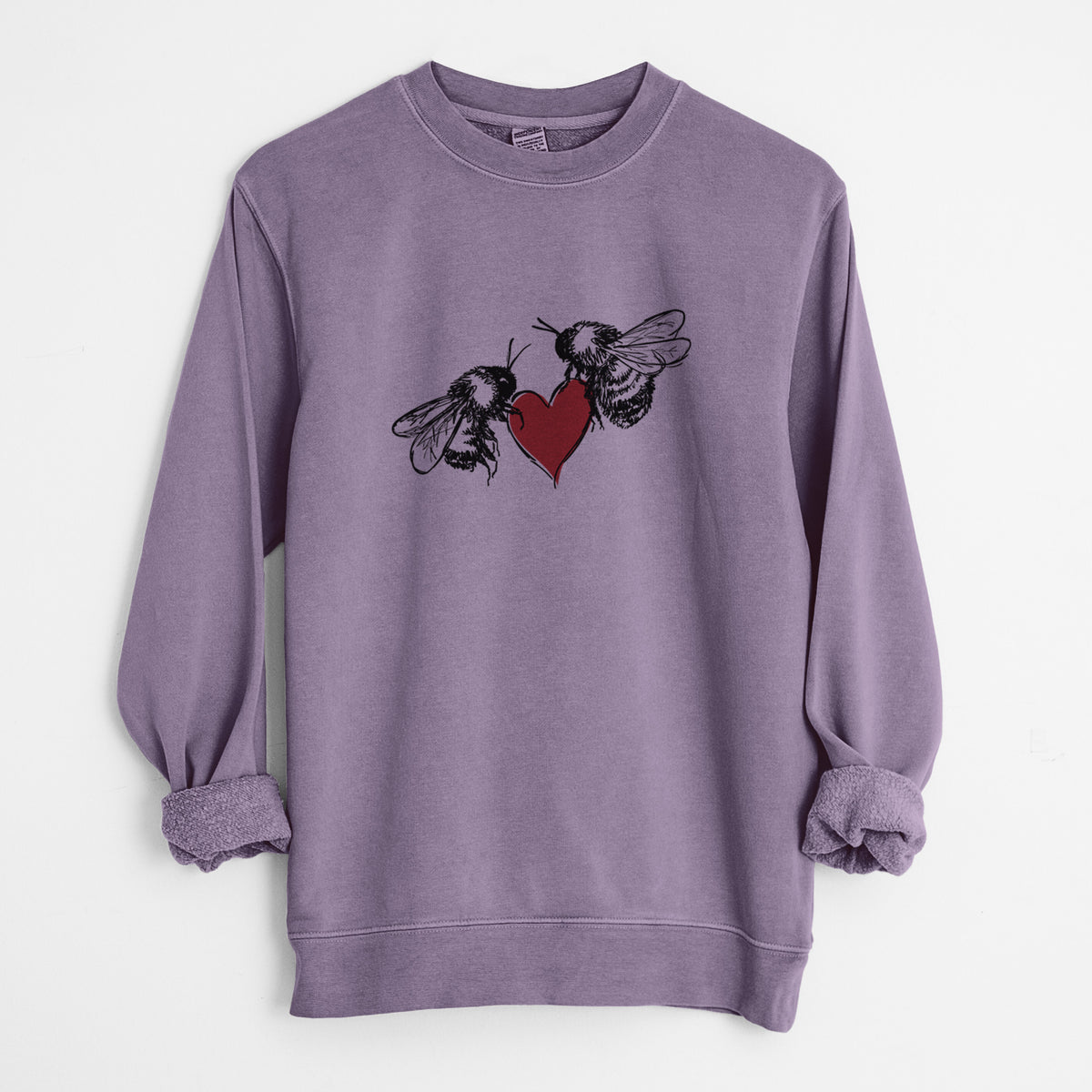 Plum purple pigment dyed crewneck sweatshirt laid flat with the sleeves rolled, printed with a black ink illustration of two bees facing each other with a red heart between them.