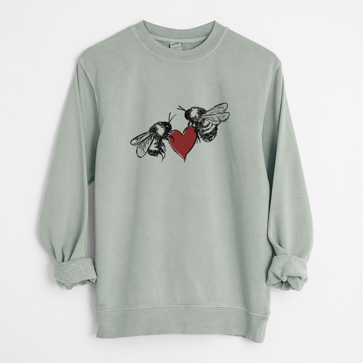 Sage green pigment dyed crewneck sweatshirt laid flat with the sleeves rolled, printed with a black ink illustration of two bees facing each other with a red heart between them.