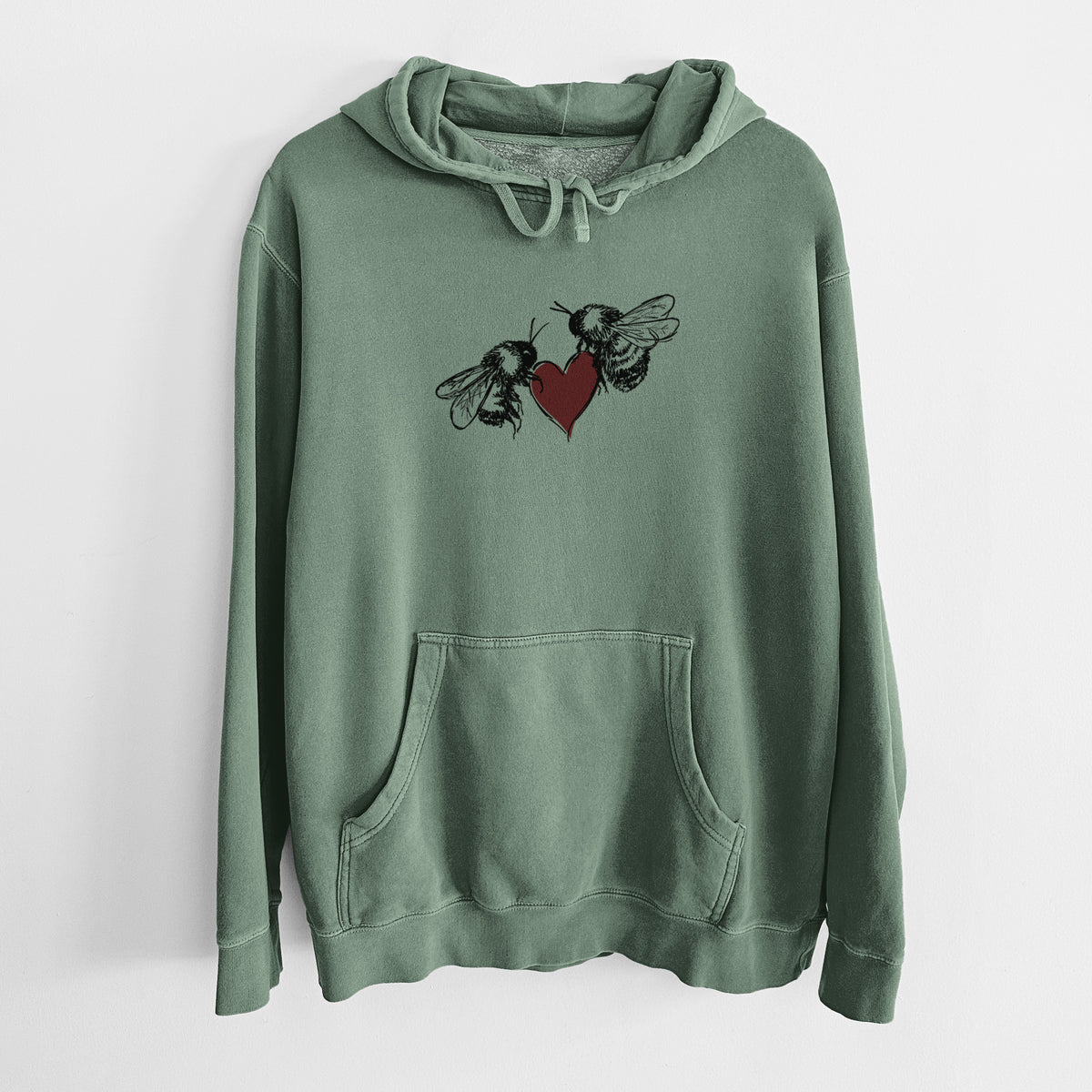 Alpine green pigment dyed hoodie laid flat, printed with a black ink illustration of two bees facing each other with a red heart between them.