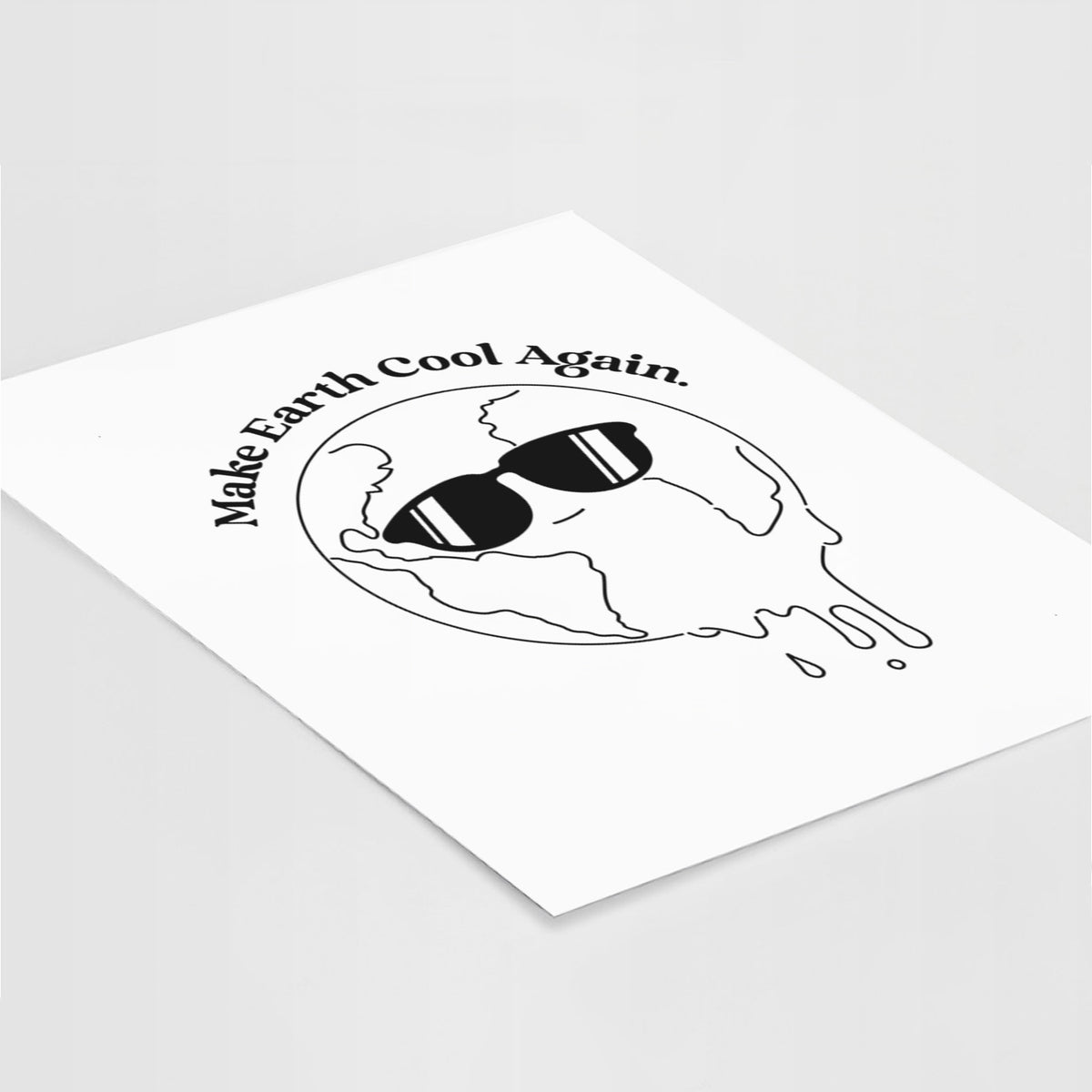 Art print of a melting Earth wearing black sunglasses, with the words Make Earth Cool Again, lying at an angle on a white surface.