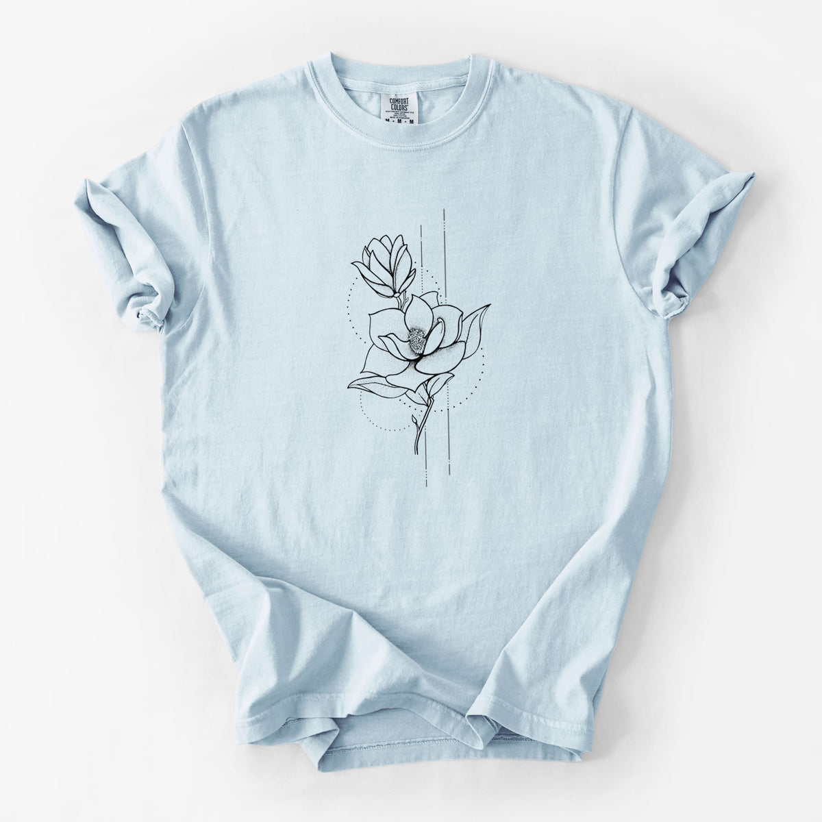 Chambray blue Comfort Colors t-shirt laid flat, printed with a black ink line drawing of a magnolia blossom on a stem.