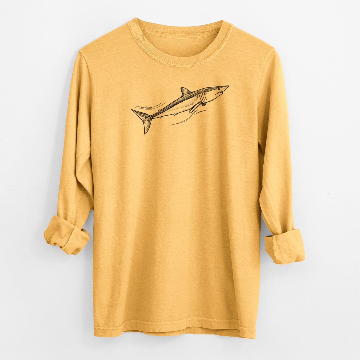 Golden wheat yellow Comfort Colors long sleeve shirt laid flat with the cuffs rolled, printed with a black ink illustration of a mako shark swimming.