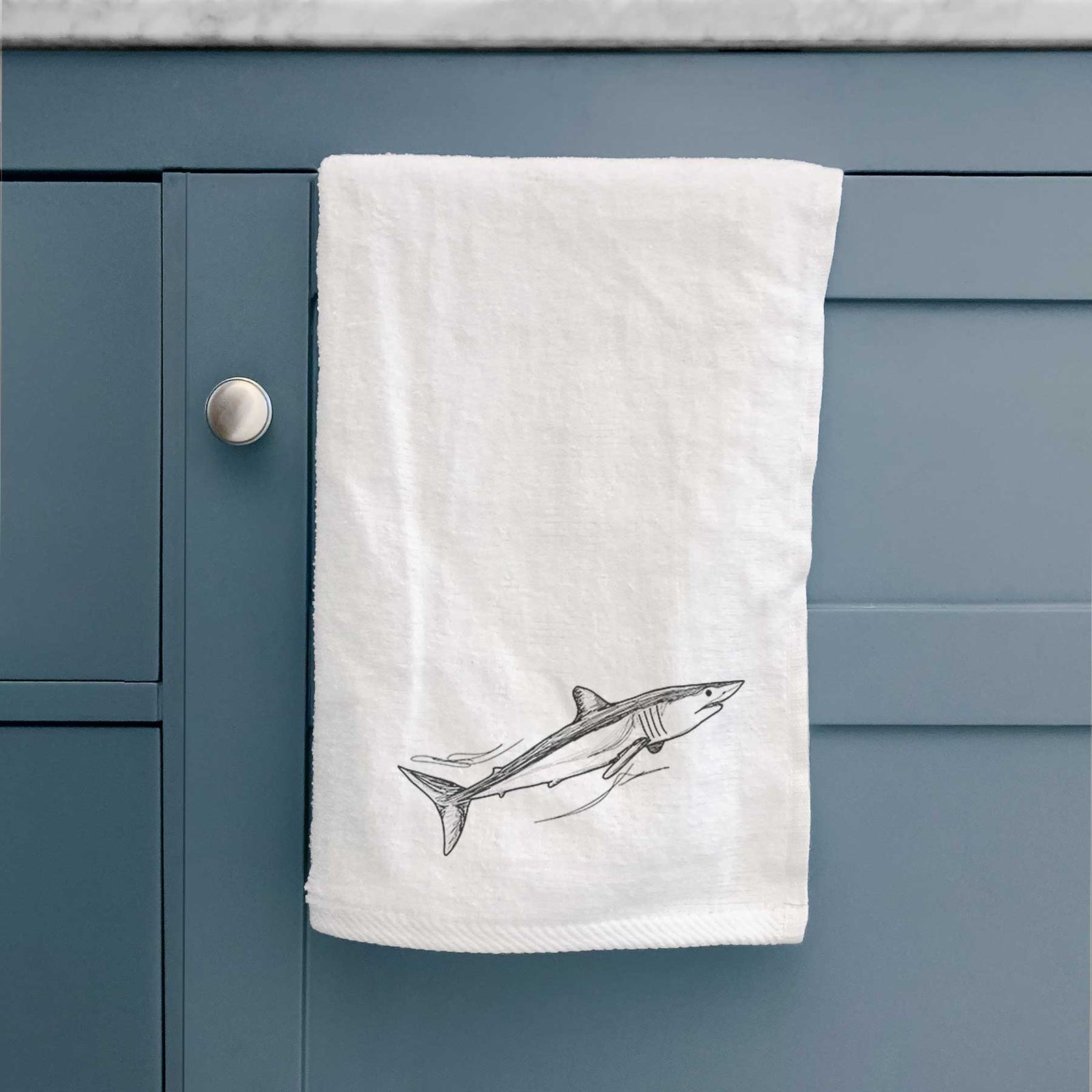 White hand towel printed with a black ink illustration of a mako shark swimming.