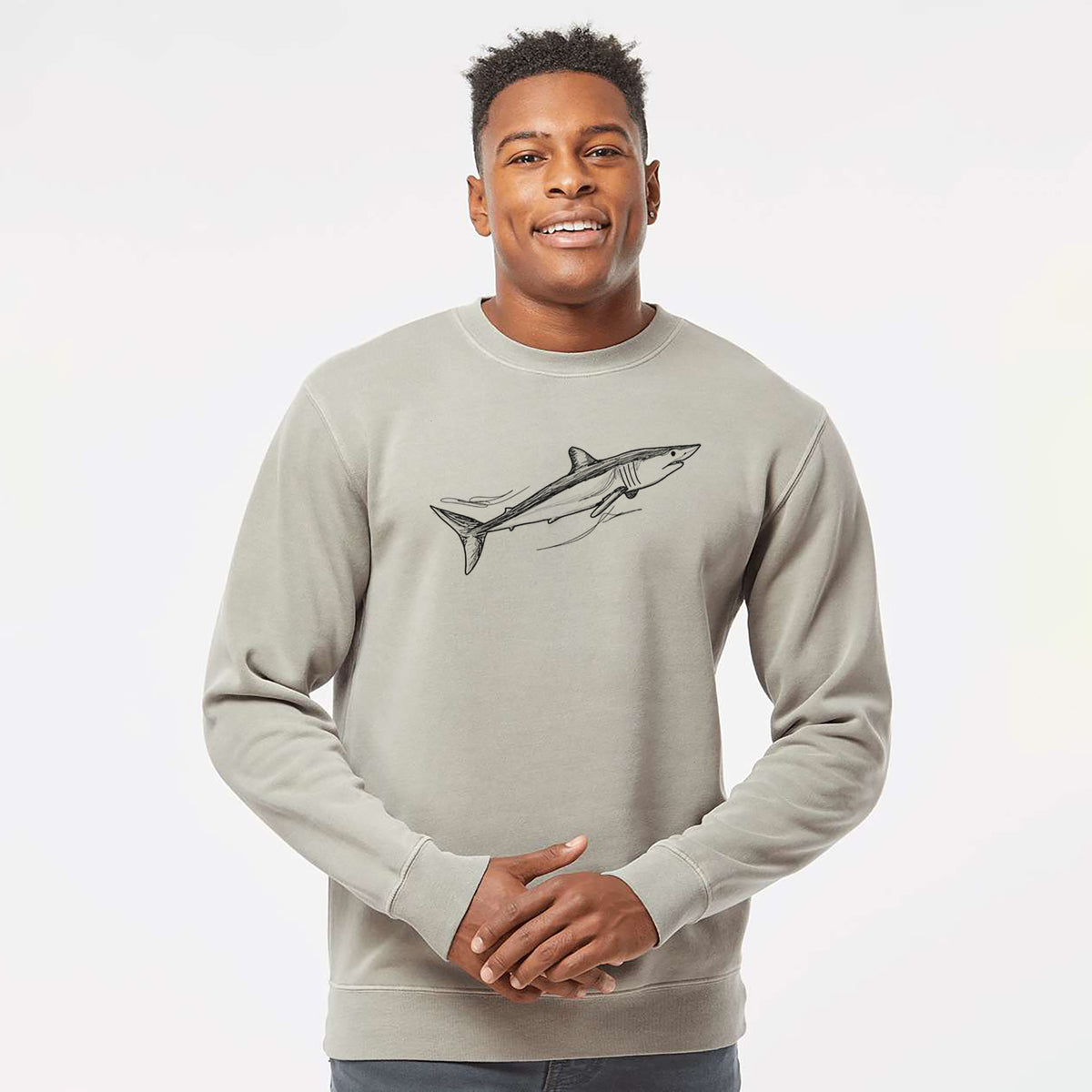 Model wearing a cement grey pigment dyed crewneck sweatshirt printed with a black ink illustration of a mako shark swimming.