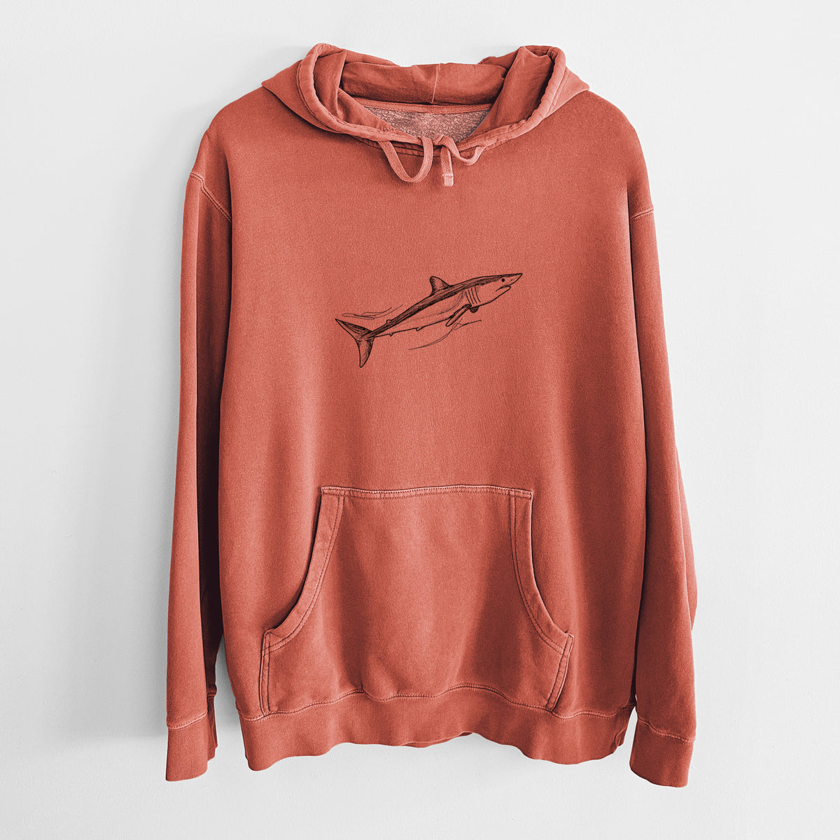 Amber orange pigment dyed hoodie laid flat, printed with a black ink illustration of a mako shark swimming.