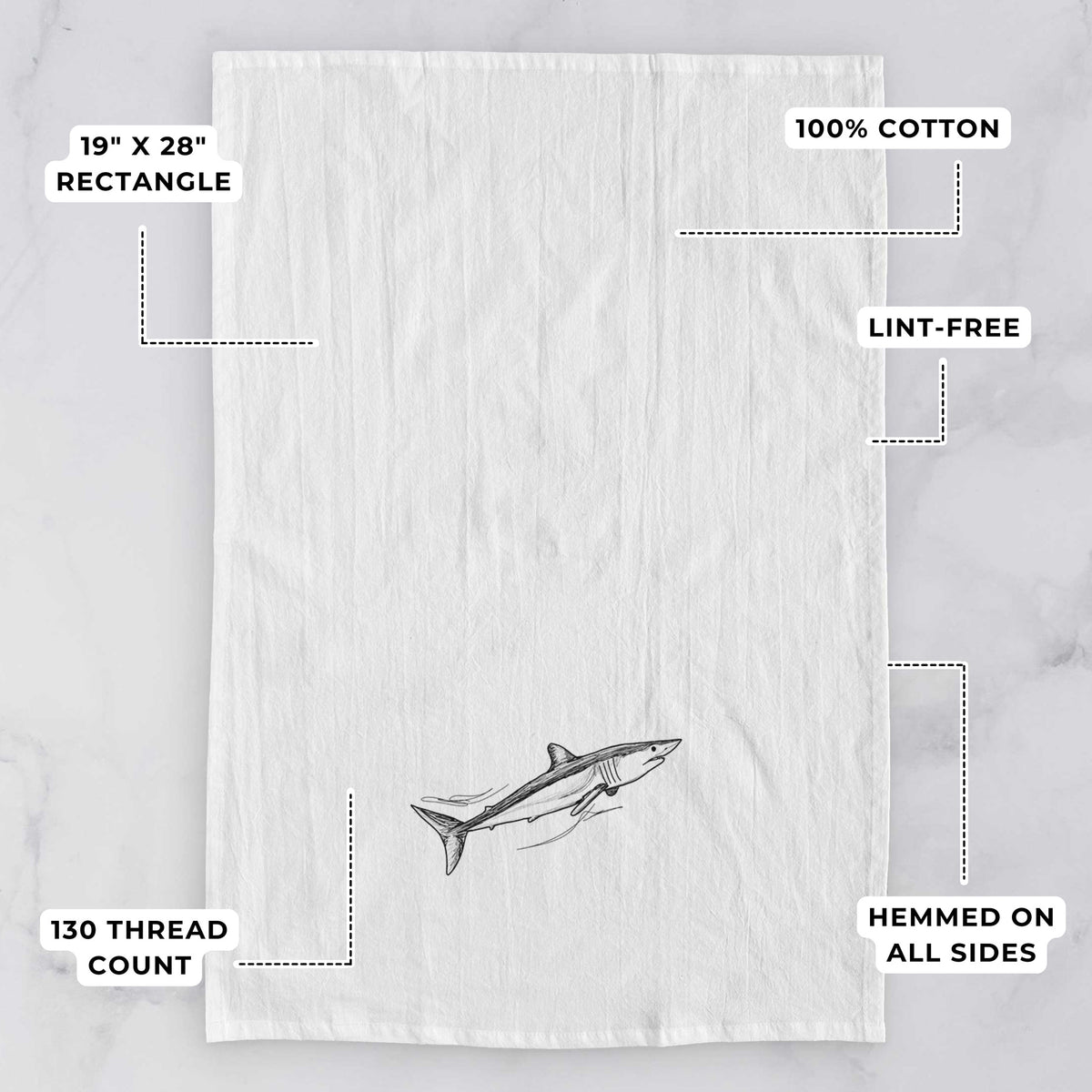 White tea towel printed with a black ink illustration of a mako shark swimming, with feature labels: 19 by 28 inch rectangle, 100% cotton, lint-free, 130 thread count, hemmed on all sides.