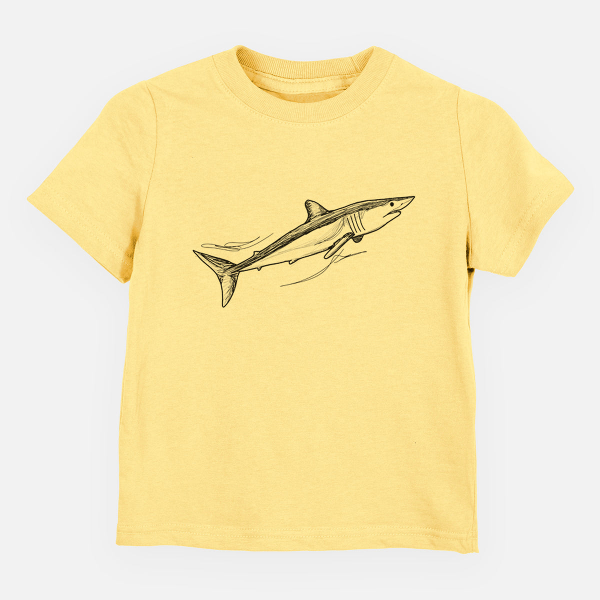 Butter yellow toddler t-shirt laid flat, printed with a black ink illustration of a mako shark swimming.