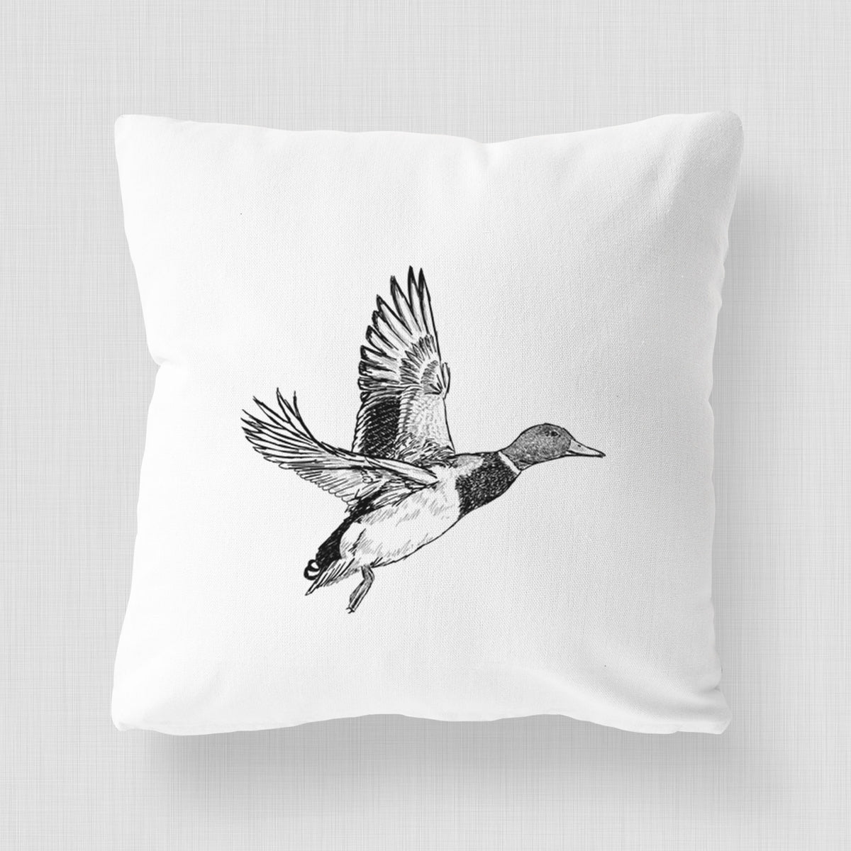 White pillow cover printed with a detailed black ink illustration of a male mallard duck taking flight.