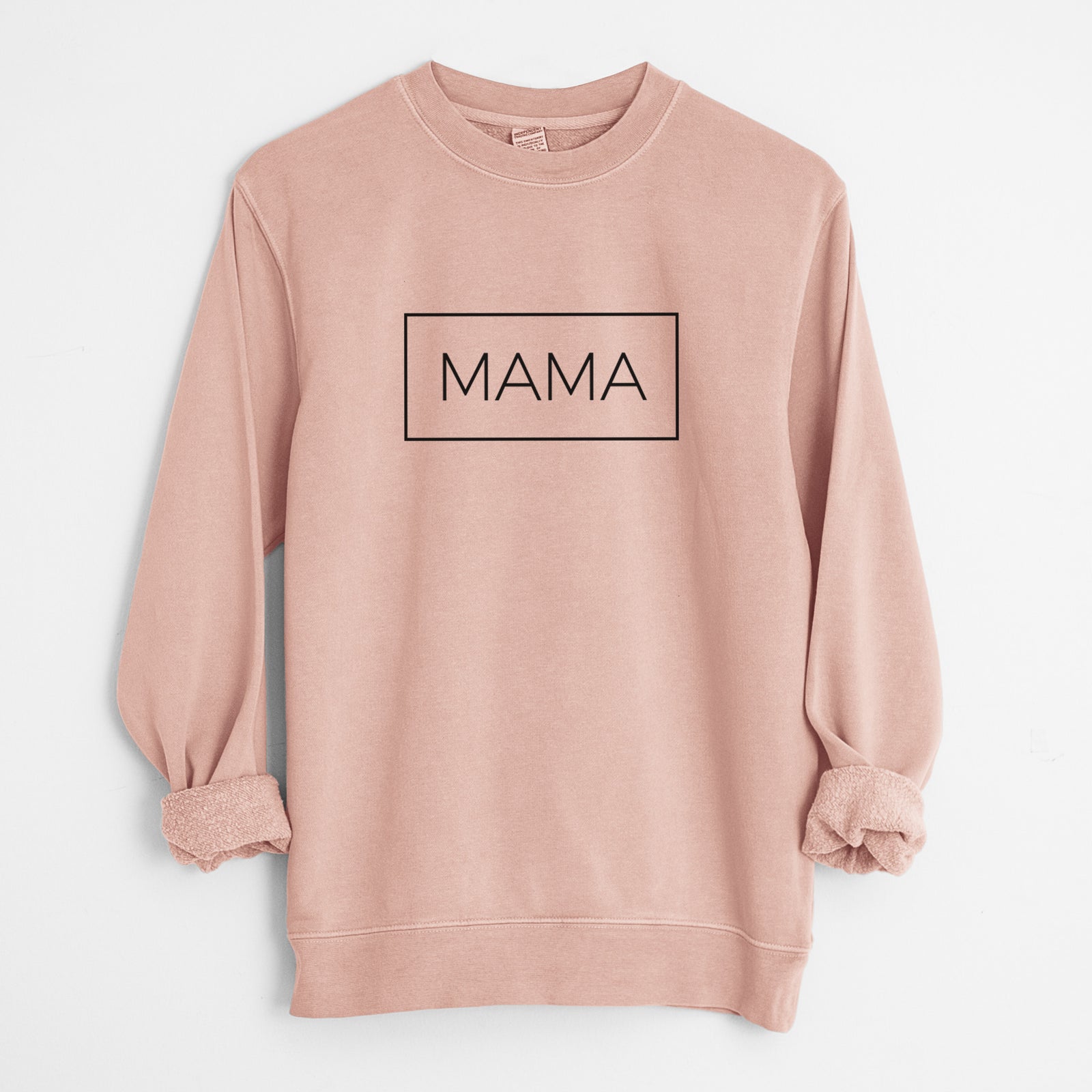 Dusty pink pigment dyed crewneck sweatshirt laid flat with the sleeves rolled, printed with the word MAMA in thin black letters inside a rectangle outline.