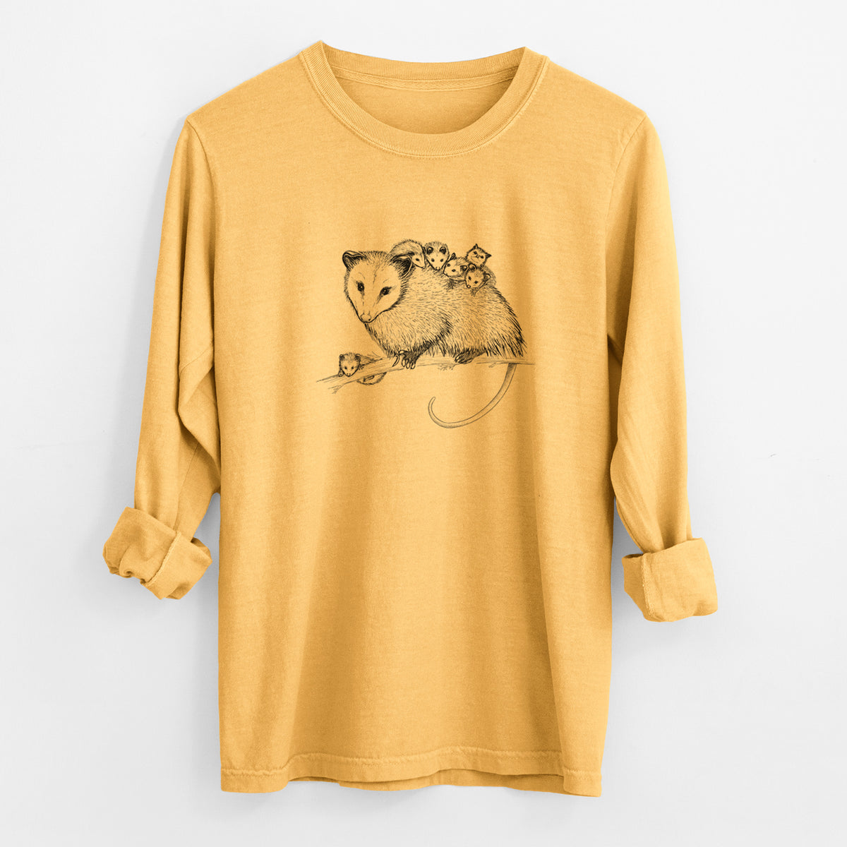 Golden wheat yellow Comfort Colors long sleeve shirt laid flat with the cuffs rolled, printed with a black ink illustration of a mother opossum on a branch carrying her babies on her back.