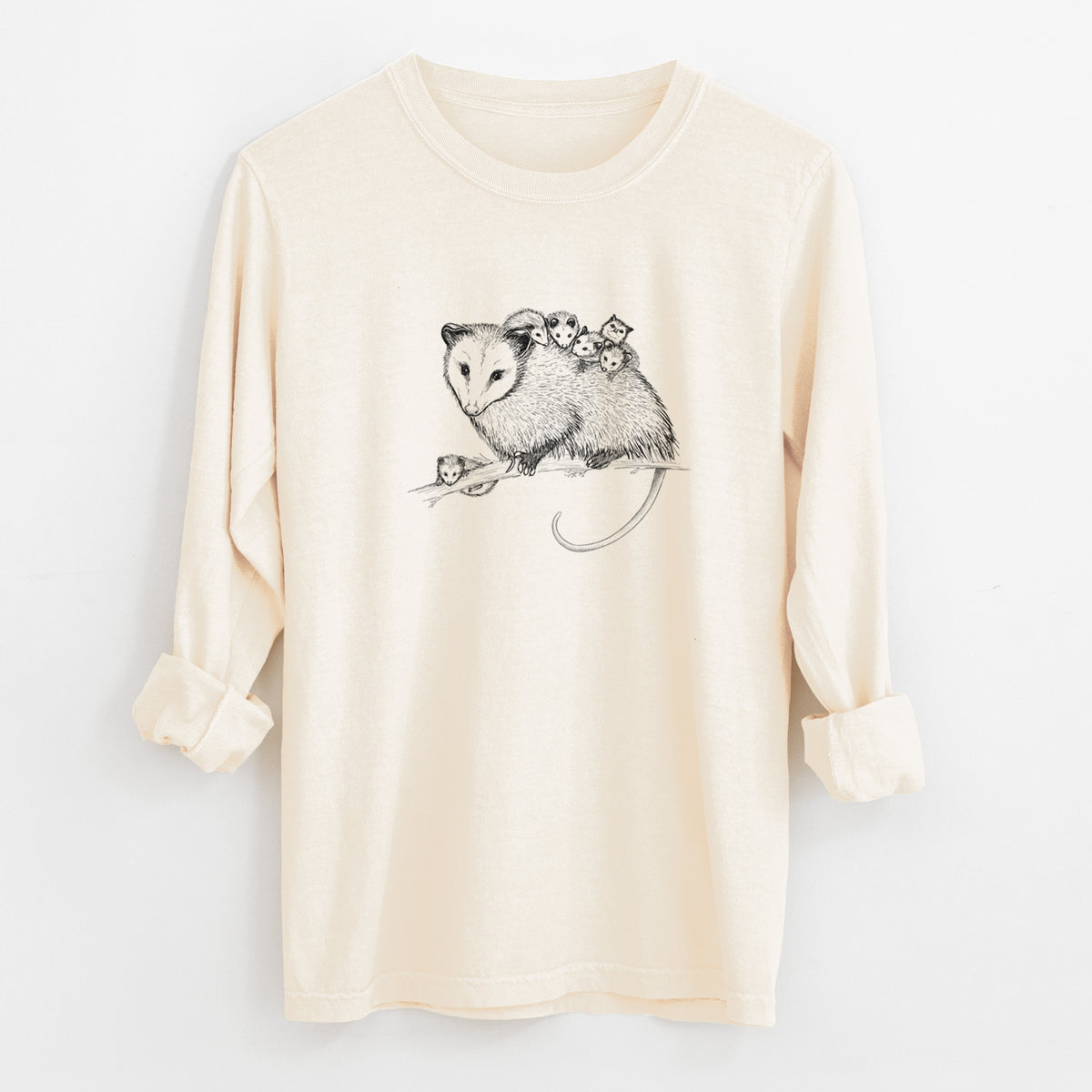Ivory Comfort Colors long sleeve shirt laid flat with the cuffs rolled, printed with a black ink illustration of a mother opossum on a branch carrying her babies on her back.
