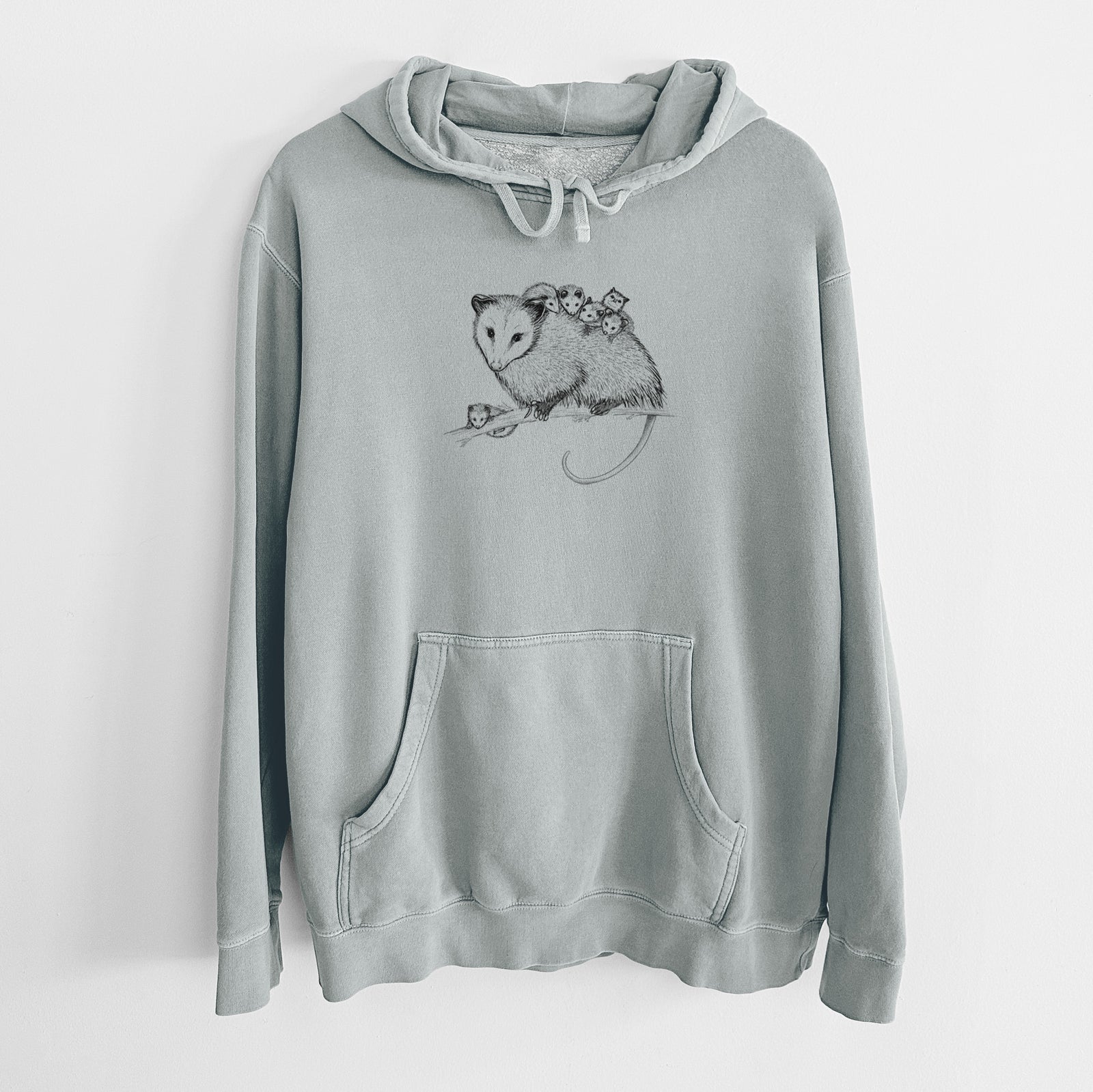 Sage green pigment dyed hoodie laid flat, printed with a black ink illustration of a mother opossum on a branch carrying her babies on her back.