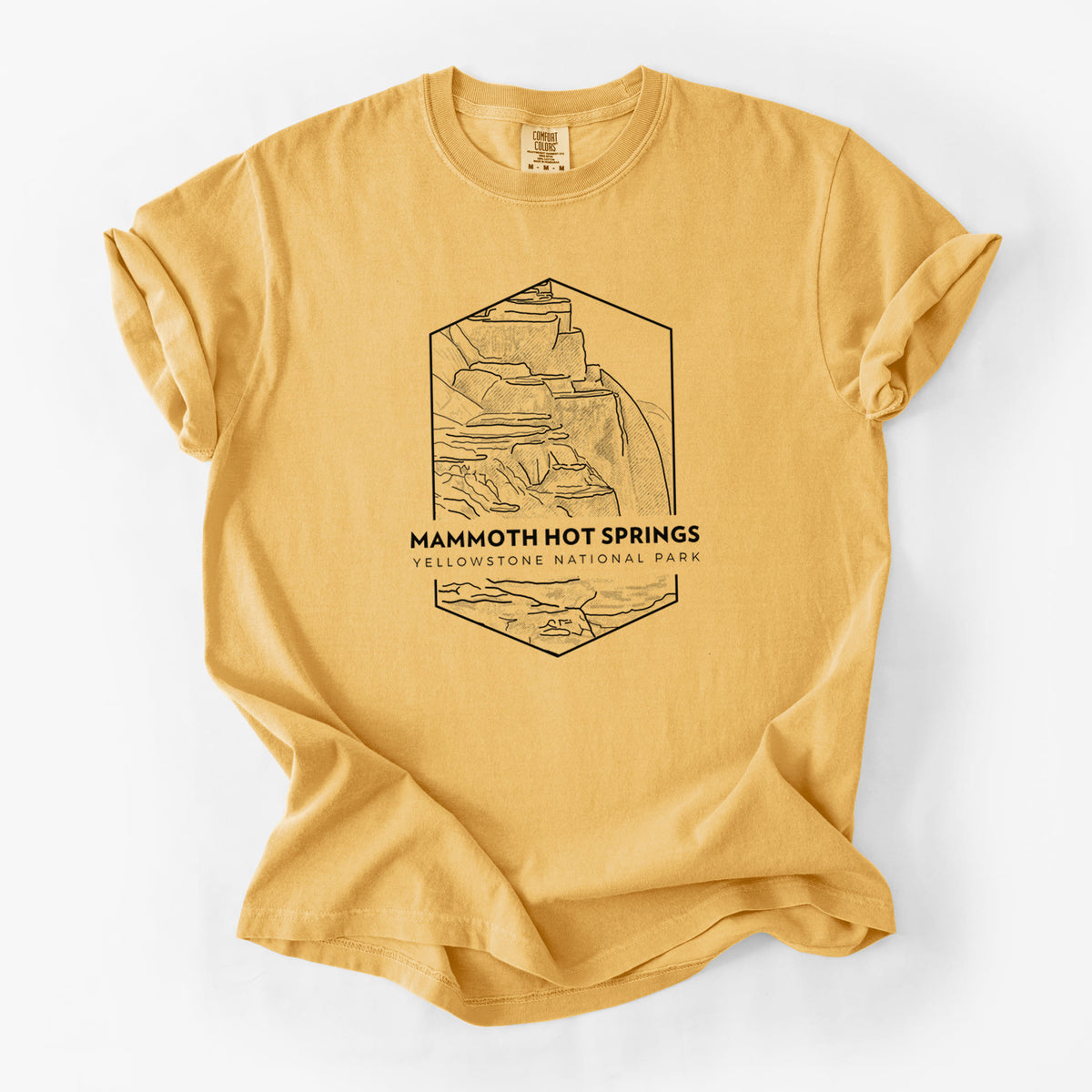 Golden wheat yellow Comfort Colors t-shirt laid flat, printed with a black line art badge of the terraces at Mammoth Hot Springs, with the words Mammoth Hot Springs, Yellowstone National Park.