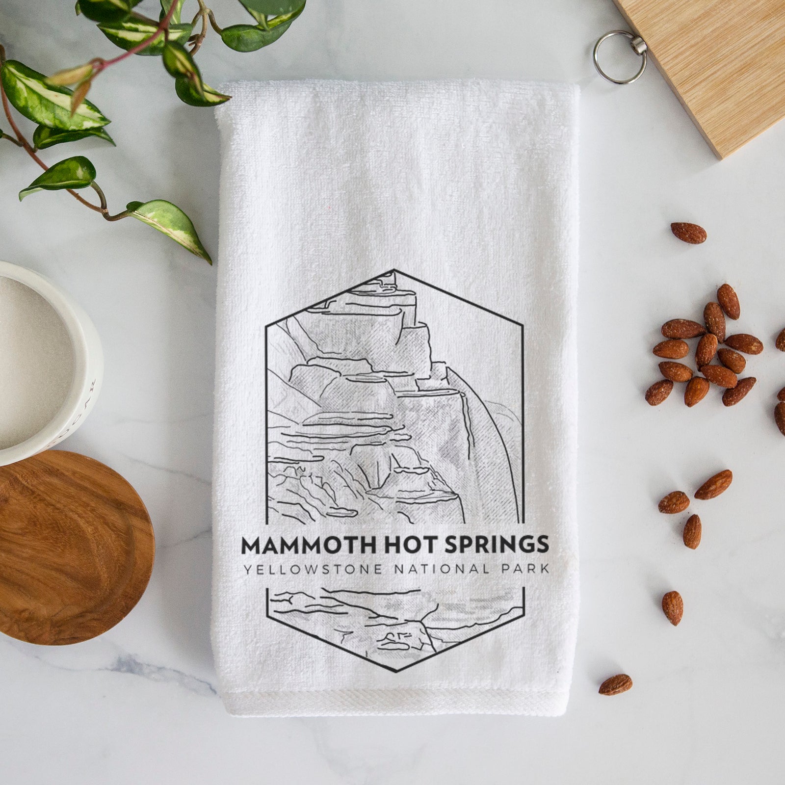 White hand towel printed with a black line art badge of the terraces at Mammoth Hot Springs, with the words Mammoth Hot Springs, Yellowstone National Park.