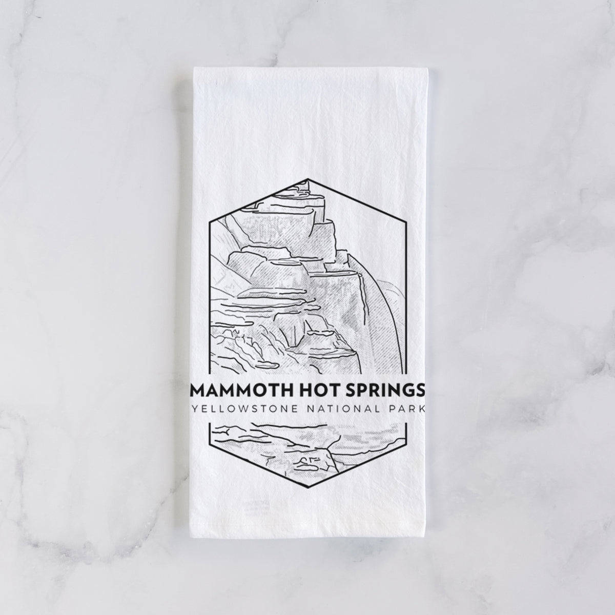 White cotton tea towel laid flat on marble, printed with a black line art badge of the terraces at Mammoth Hot Springs, with the words Mammoth Hot Springs, Yellowstone National Park.