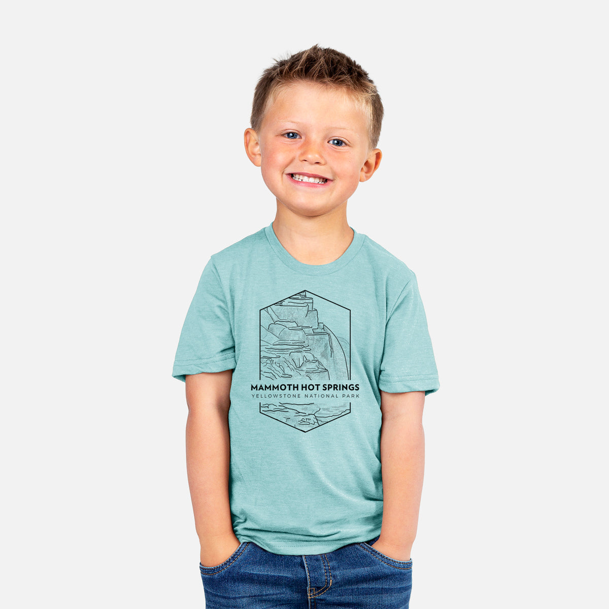 Smiling boy wearing a youth t-shirt printed with a black line art badge of the terraces at Mammoth Hot Springs, with the words Mammoth Hot Springs, Yellowstone National Park.