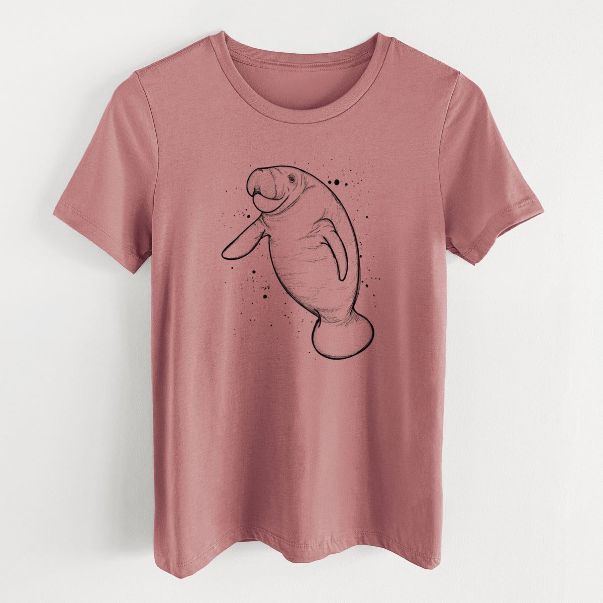 Mauve pink women's relaxed fit cotton t-shirt laid flat, printed with a black ink line drawing of a manatee swimming, with ink splatters.