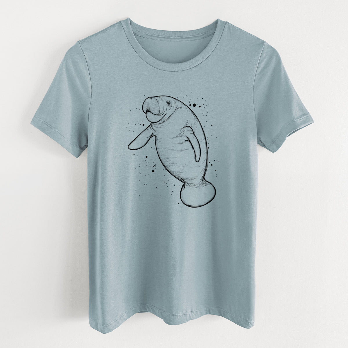 Vintage denim women's relaxed fit cotton t-shirt laid flat, printed with a black ink line drawing of a manatee swimming, with ink splatters.
