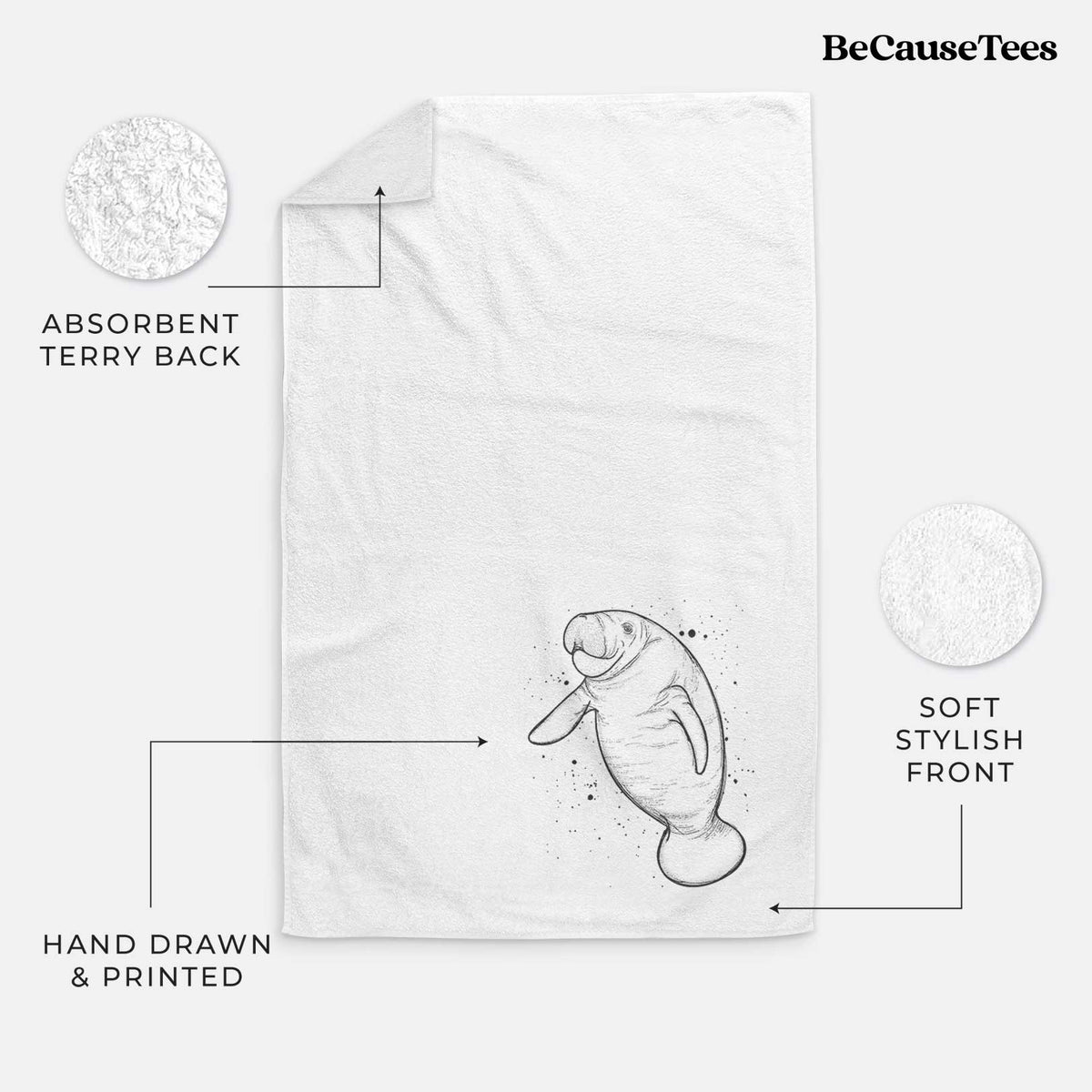 White hand towel printed with a black ink line drawing of a manatee swimming, with ink splatters.