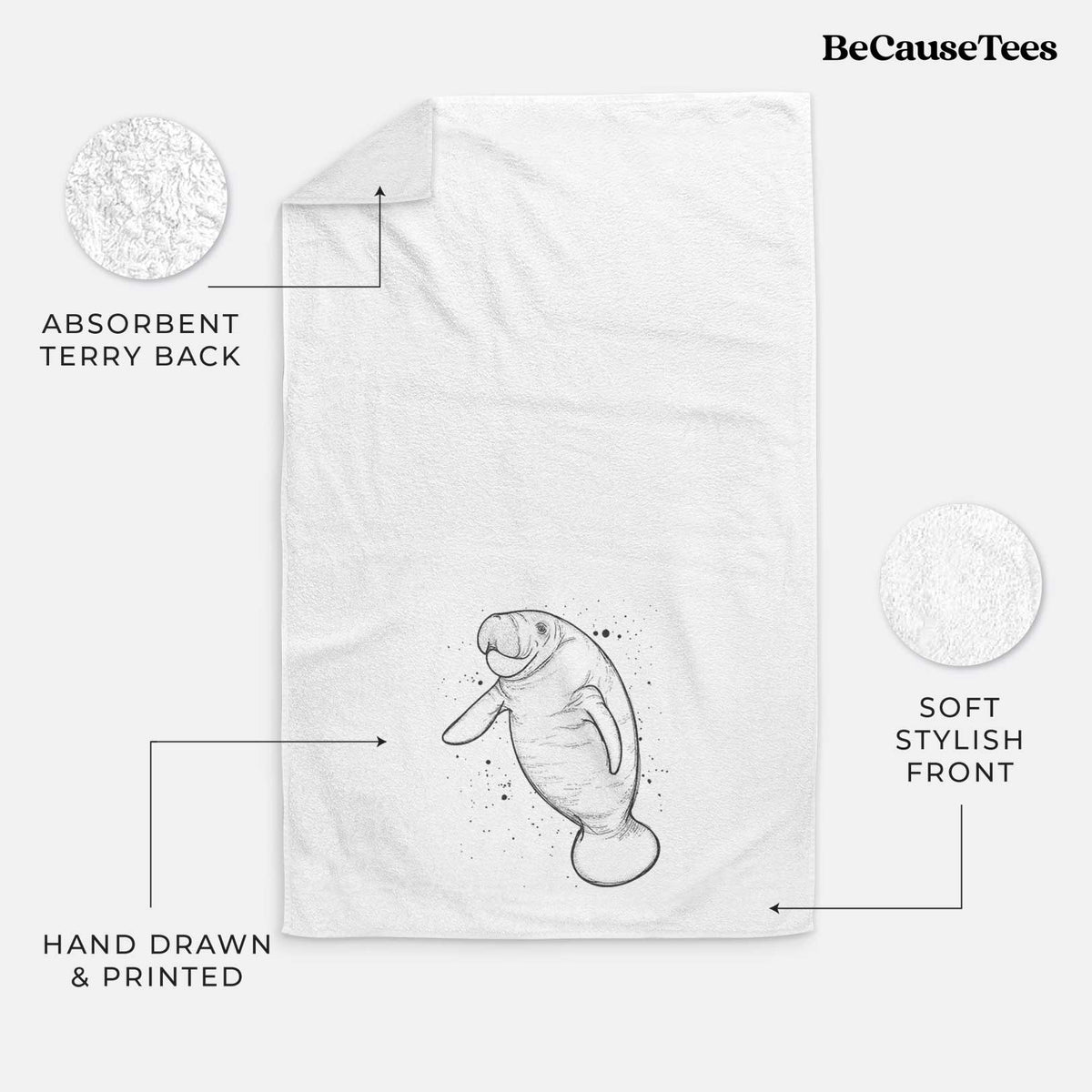 White hand towel printed with a black ink line drawing of a manatee swimming, with ink splatters.