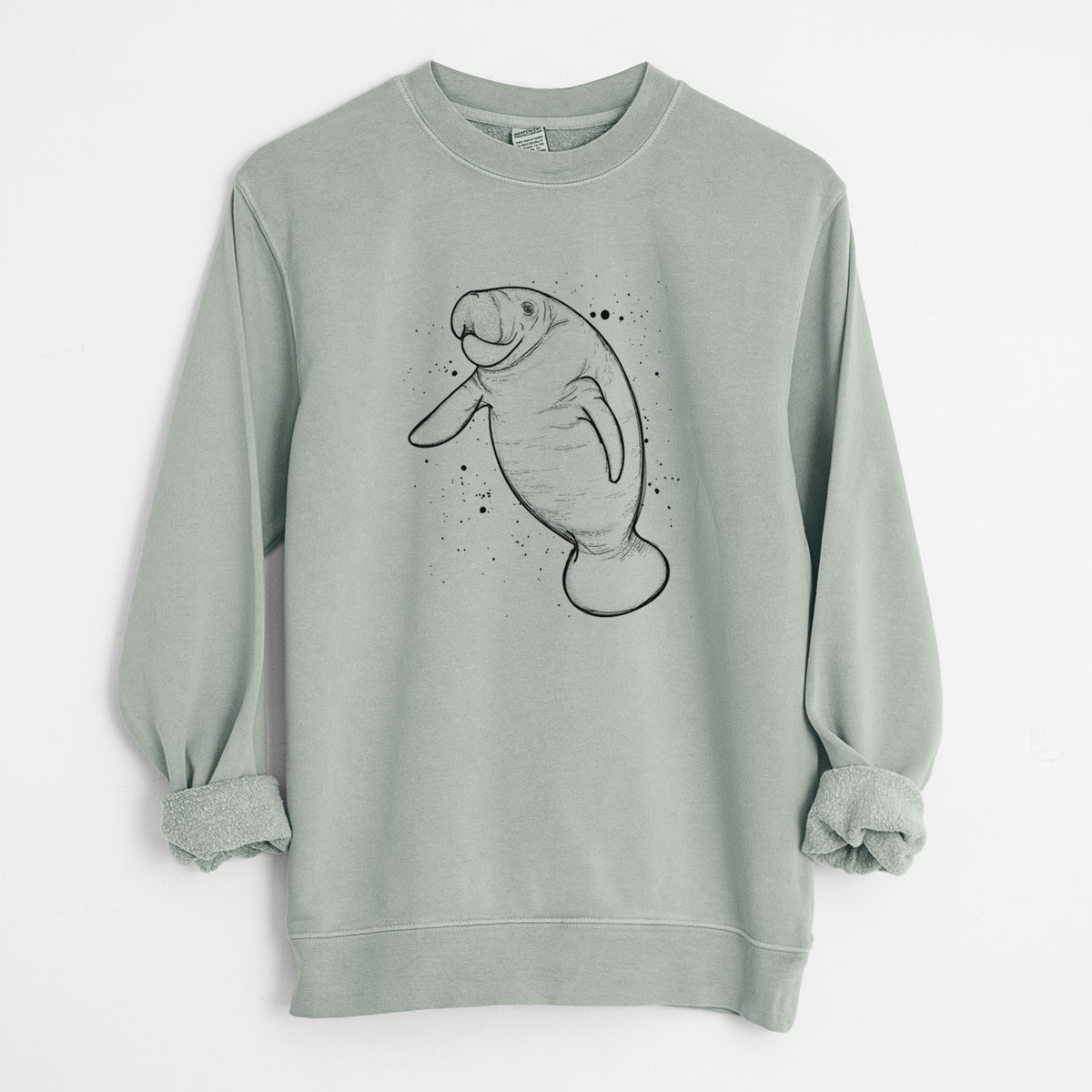 Sage green pigment dyed crewneck sweatshirt laid flat with the sleeves rolled, printed with a black ink line drawing of a manatee swimming, with ink splatters.