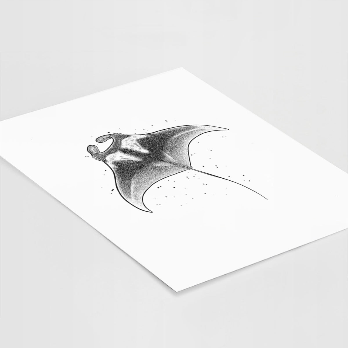 Art print of a black ink illustration of a manta ray gliding, lying at an angle on a white surface.