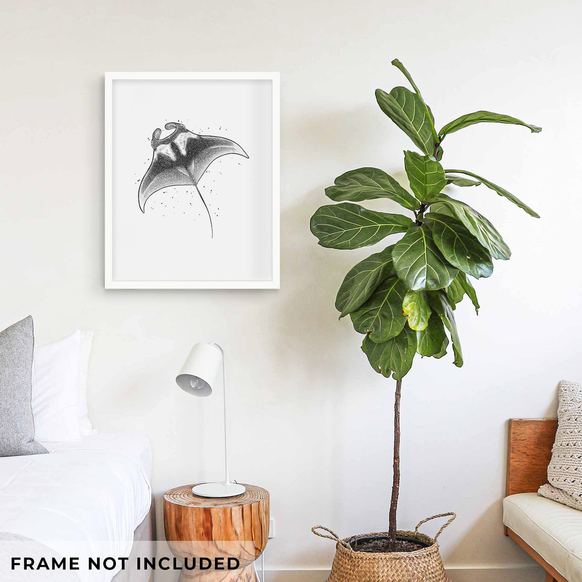 Art print of a black ink illustration of a manta ray gliding, shown framed on a living room wall beside a potted plant. Frame not included.