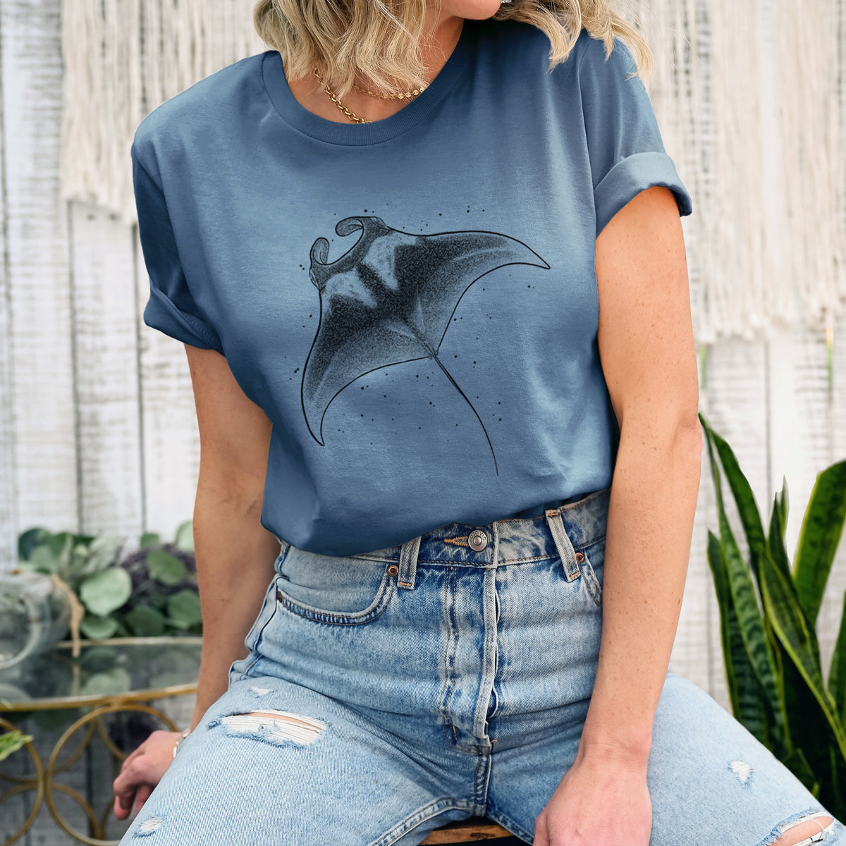 Woman wearing a steel blue lightweight cotton t-shirt printed with a black ink illustration of a manta ray gliding.