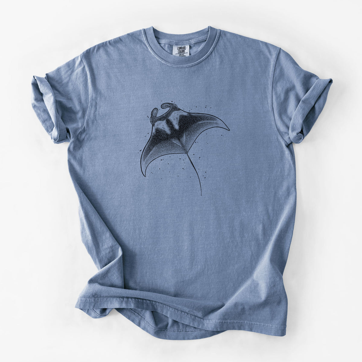 Blue jean Comfort Colors t-shirt laid flat, printed with a black ink illustration of a manta ray gliding.