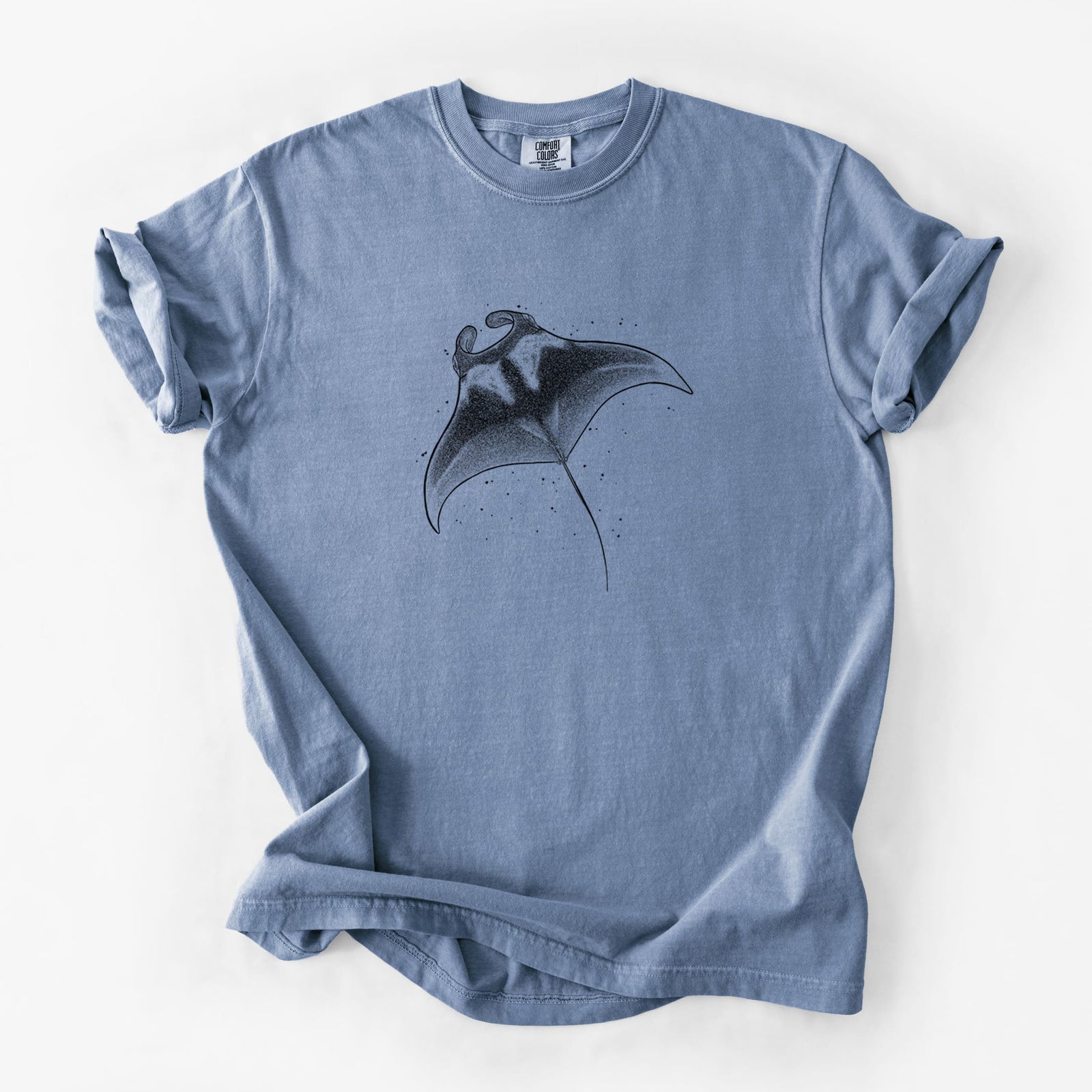 Blue jean Comfort Colors t-shirt laid flat, printed with a black ink illustration of a manta ray gliding.