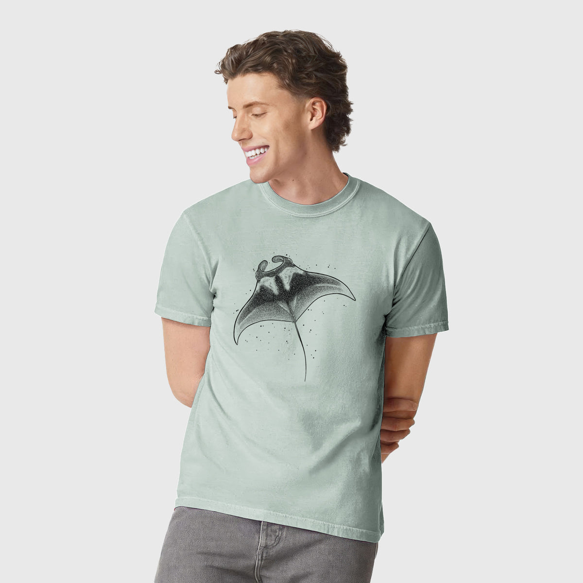 Man wearing a Comfort Colors t-shirt printed with a black ink illustration of a manta ray gliding.