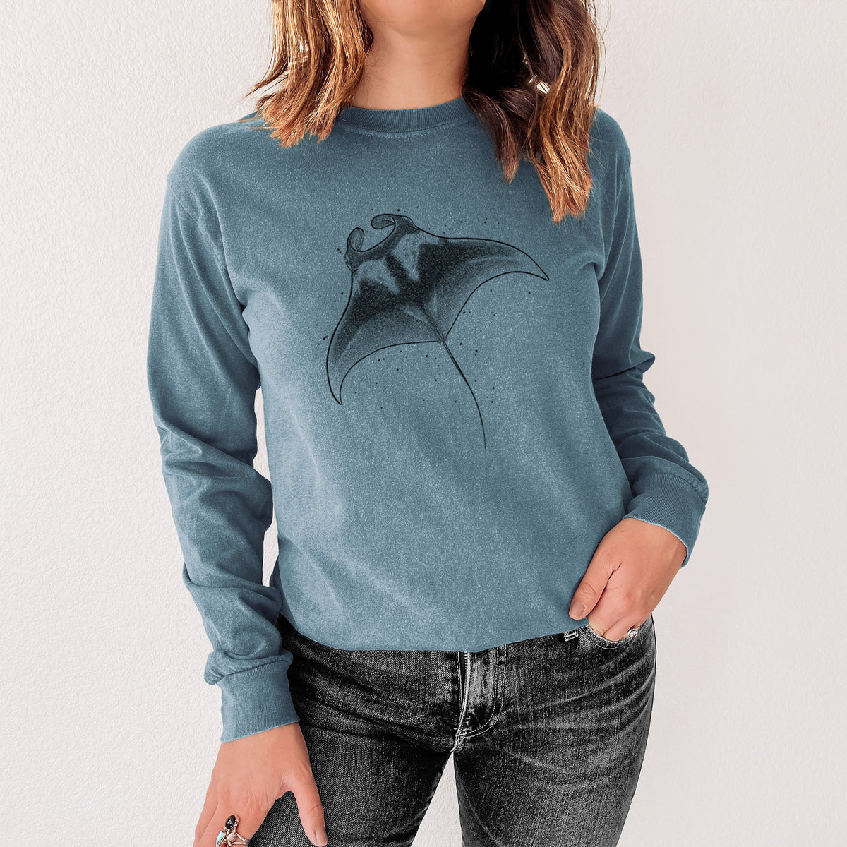 Steel blue Comfort Colors long sleeve shirt printed with a black ink illustration of a manta ray gliding, shown in a lifestyle photo.