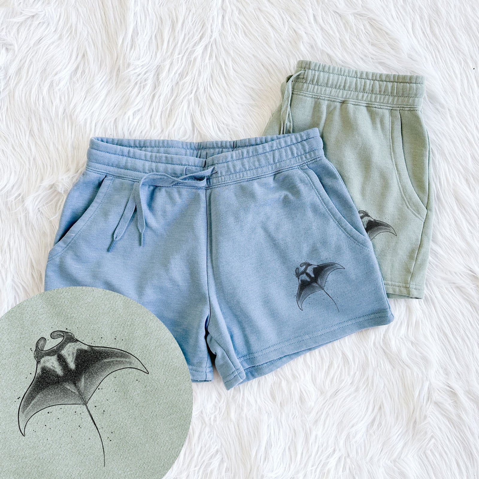 Two pairs of Cali Wave shorts in different colors printed with a black ink illustration of a manta ray gliding, with a close-up of the print.