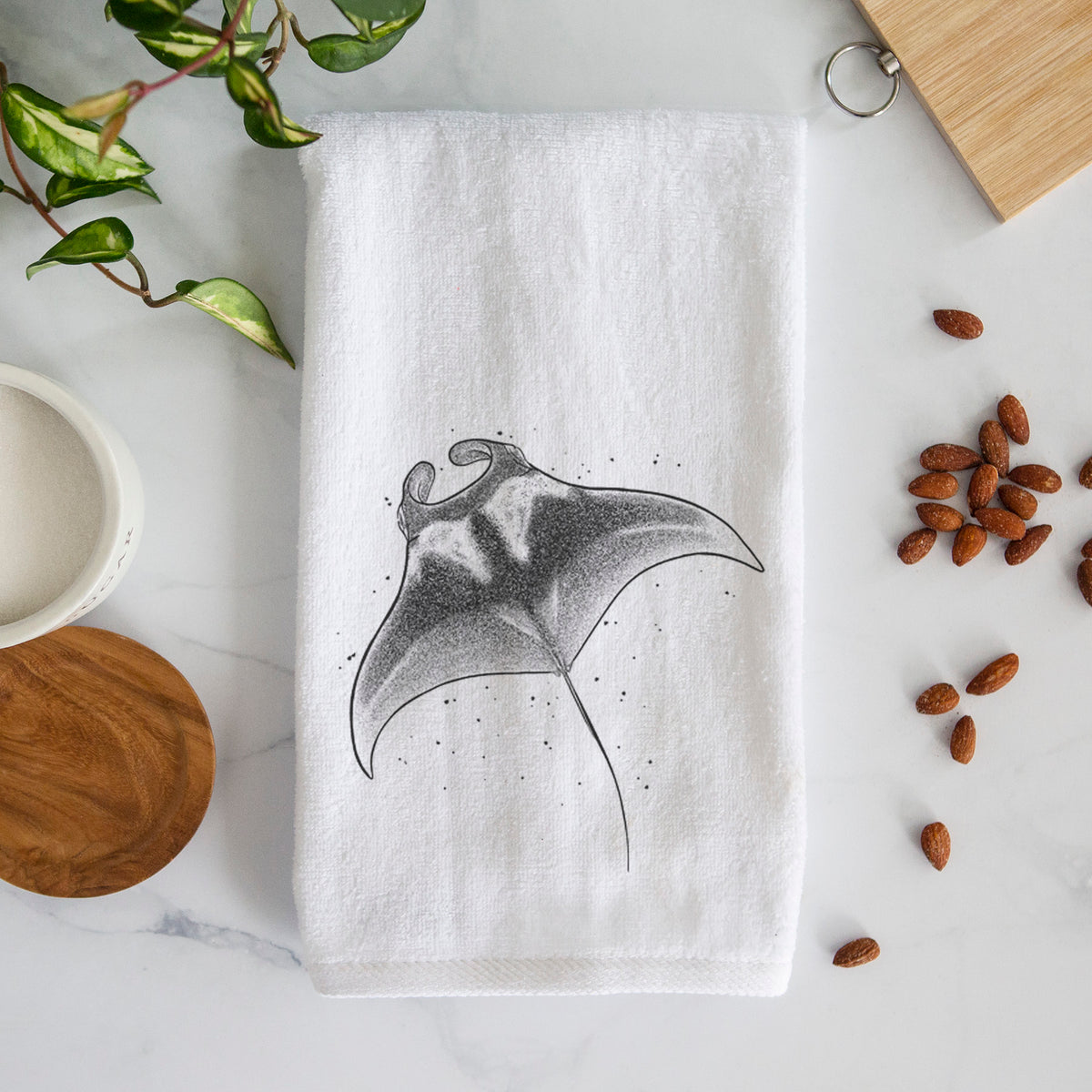 White hand towel printed with a black ink illustration of a manta ray gliding.