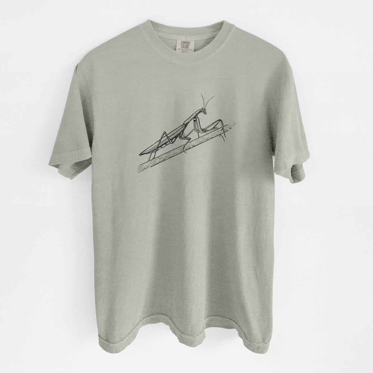 Sandstone beige Comfort Colors t-shirt laid flat, printed with a detailed black ink illustration of a praying mantis on a stem.