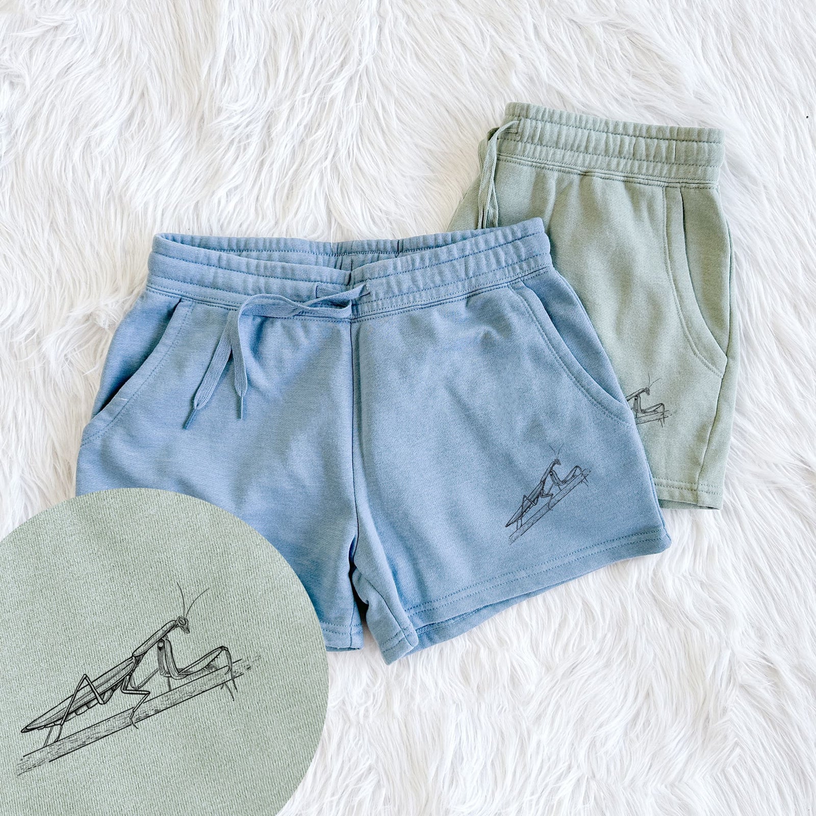 Two pairs of Cali Wave shorts in different colors printed with a detailed black ink illustration of a praying mantis on a stem, with a close-up of the print.