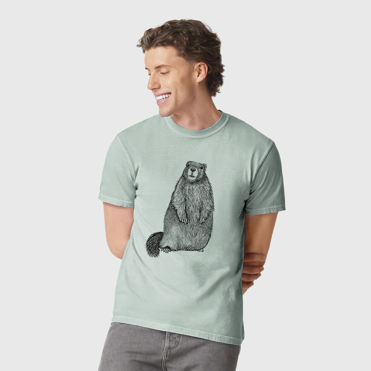 Man wearing a Comfort Colors t-shirt printed with a detailed black ink illustration of a marmot standing upright.