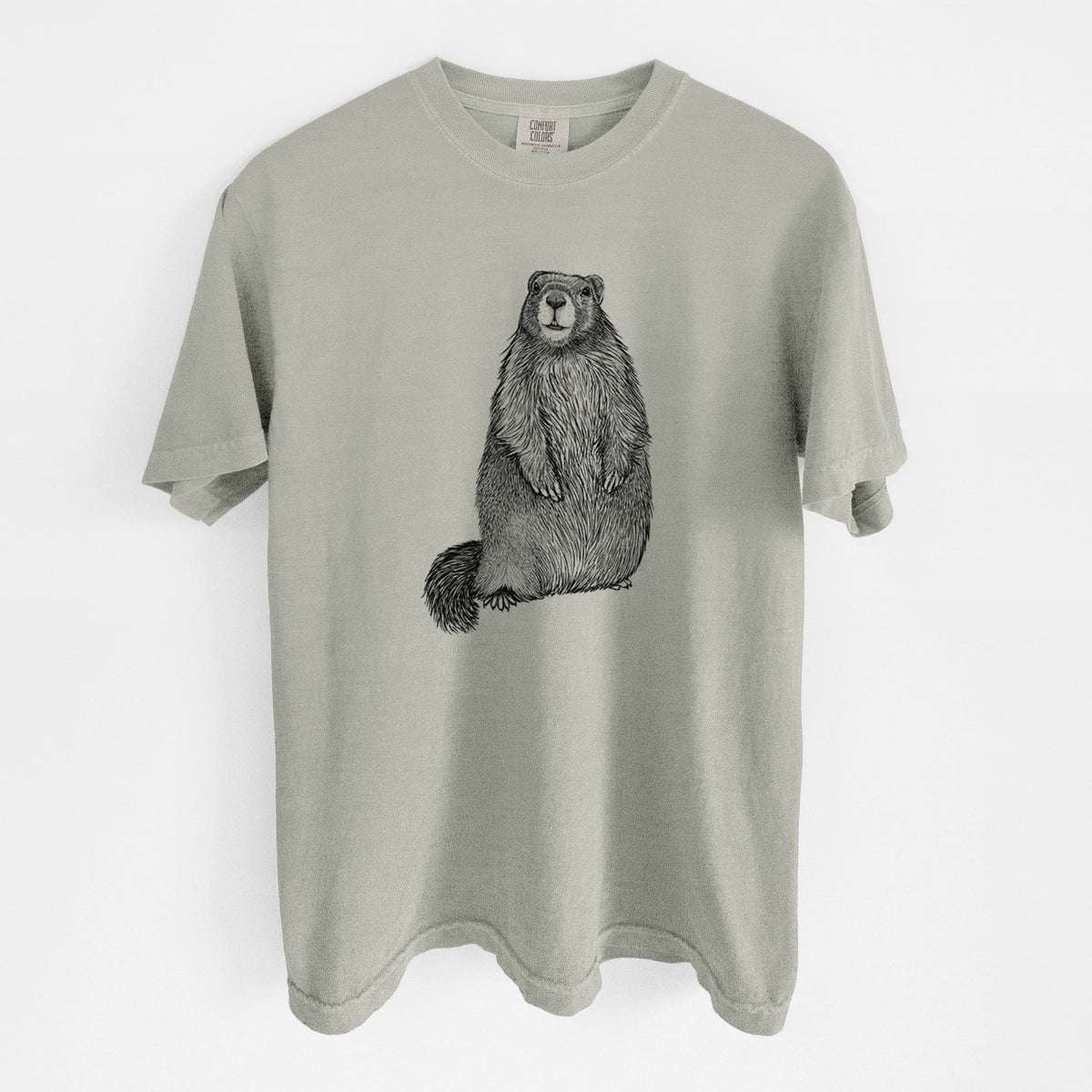 Sandstone beige Comfort Colors t-shirt laid flat, printed with a detailed black ink illustration of a marmot standing upright.