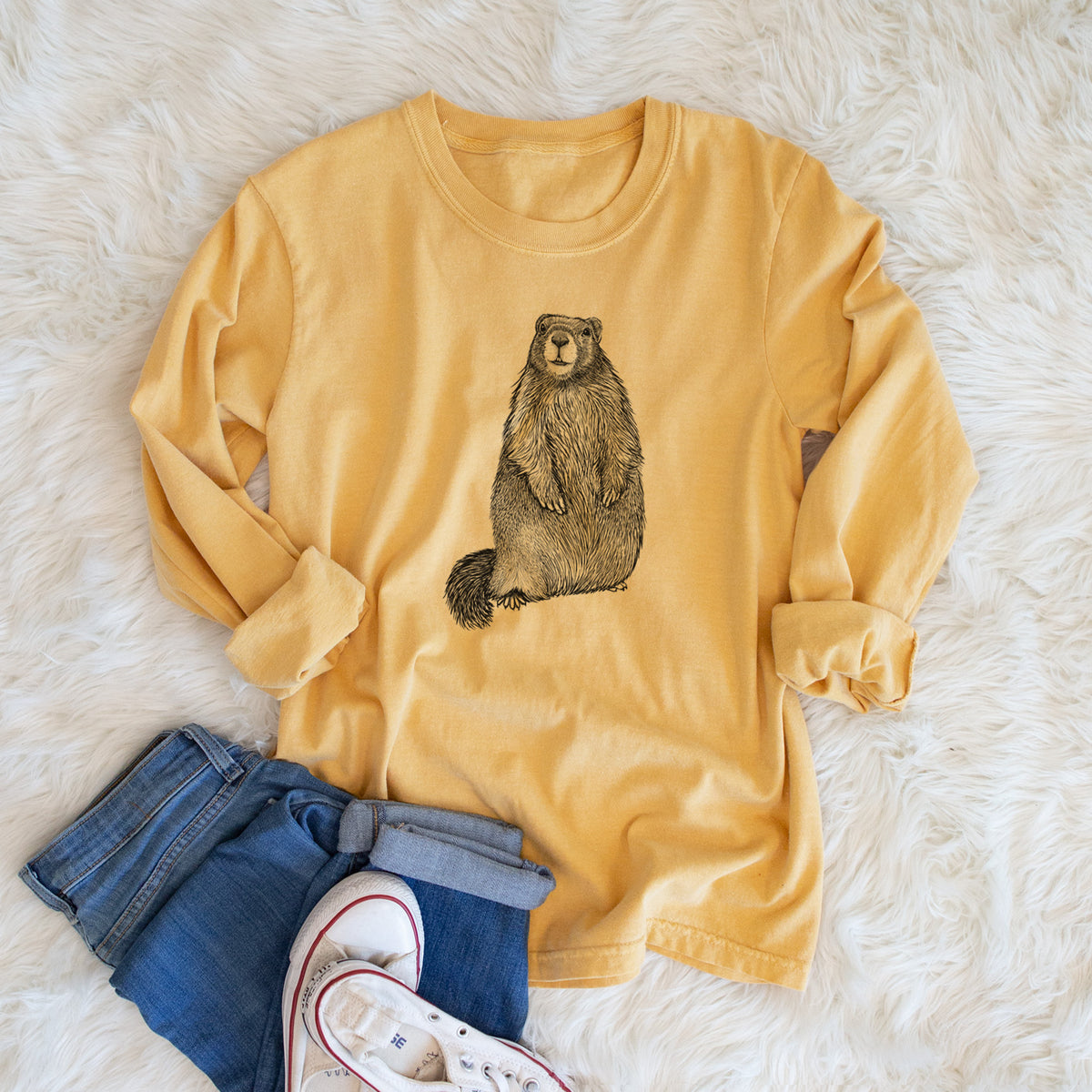 Golden wheat yellow Comfort Colors long sleeve shirt printed with a detailed black ink illustration of a marmot standing upright, shown in a lifestyle photo.