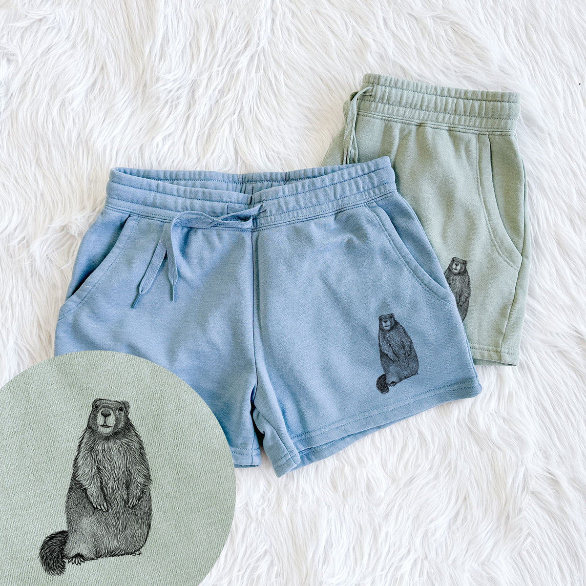 Two pairs of Cali Wave shorts in different colors printed with a detailed black ink illustration of a marmot standing upright, with a close-up of the print.