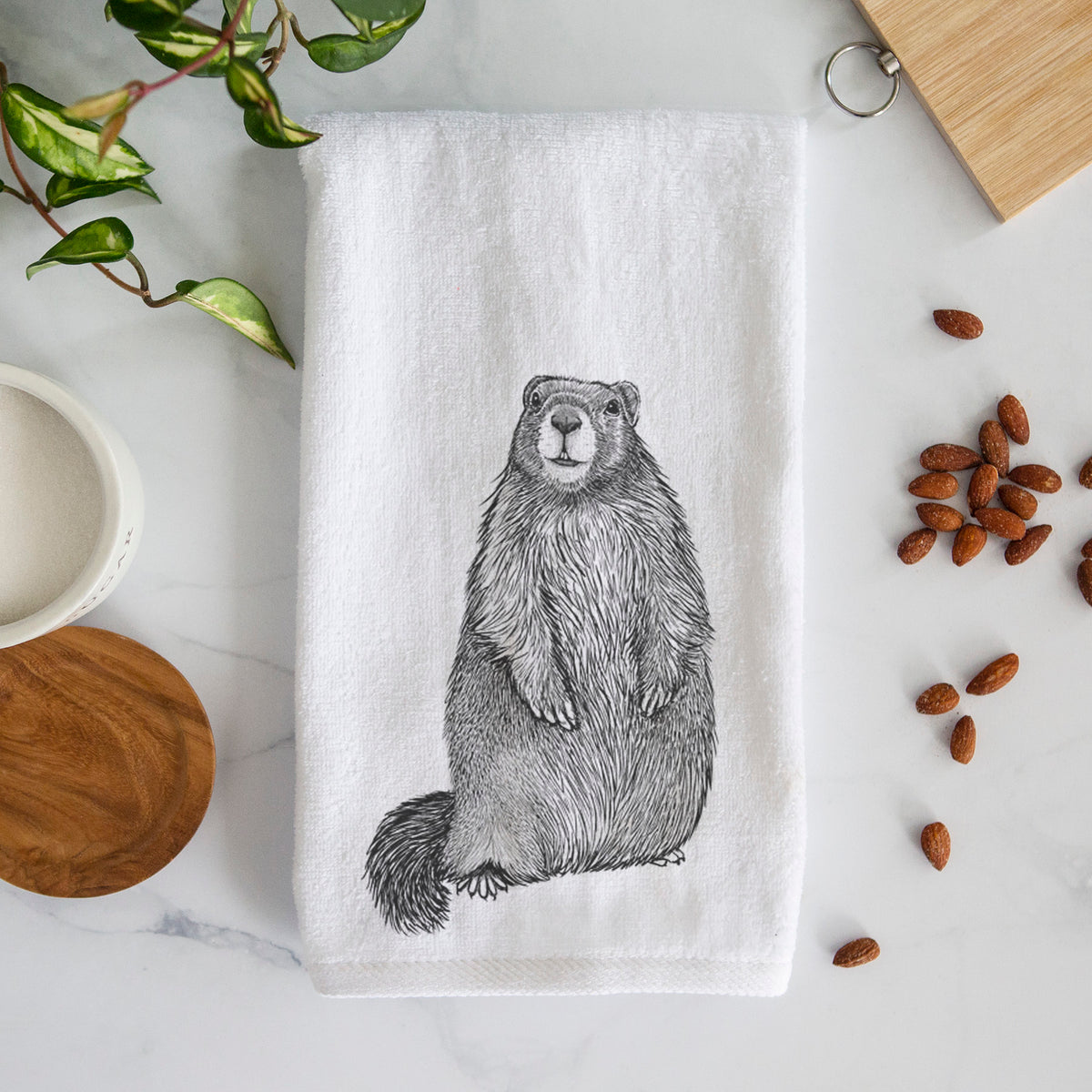 White hand towel printed with a detailed black ink illustration of a marmot standing upright.