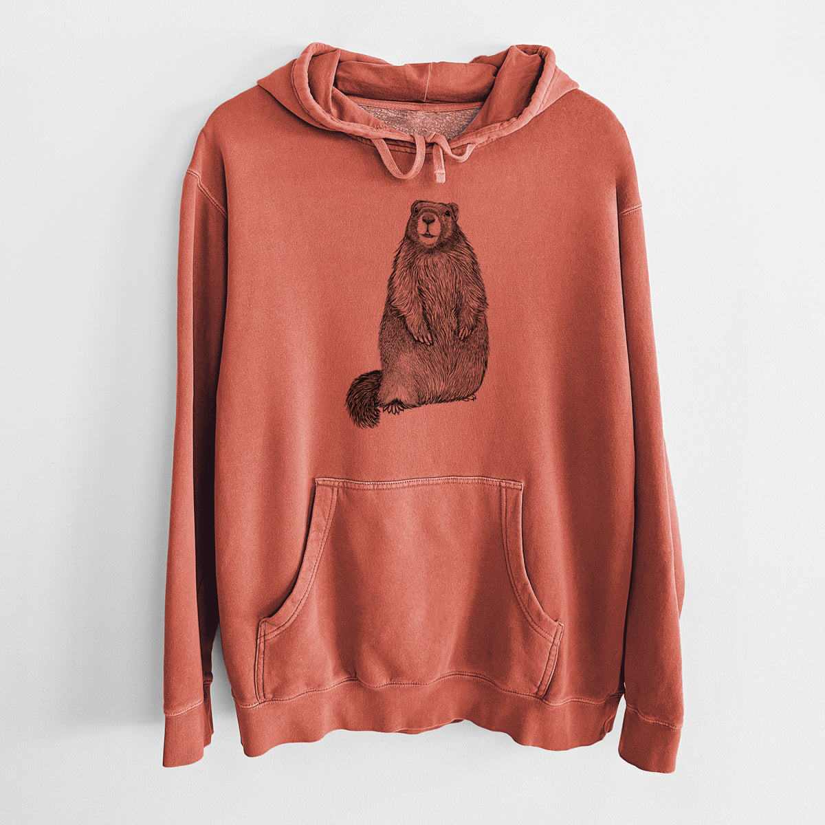 Amber orange pigment dyed hoodie laid flat, printed with a detailed black ink illustration of a marmot standing upright.