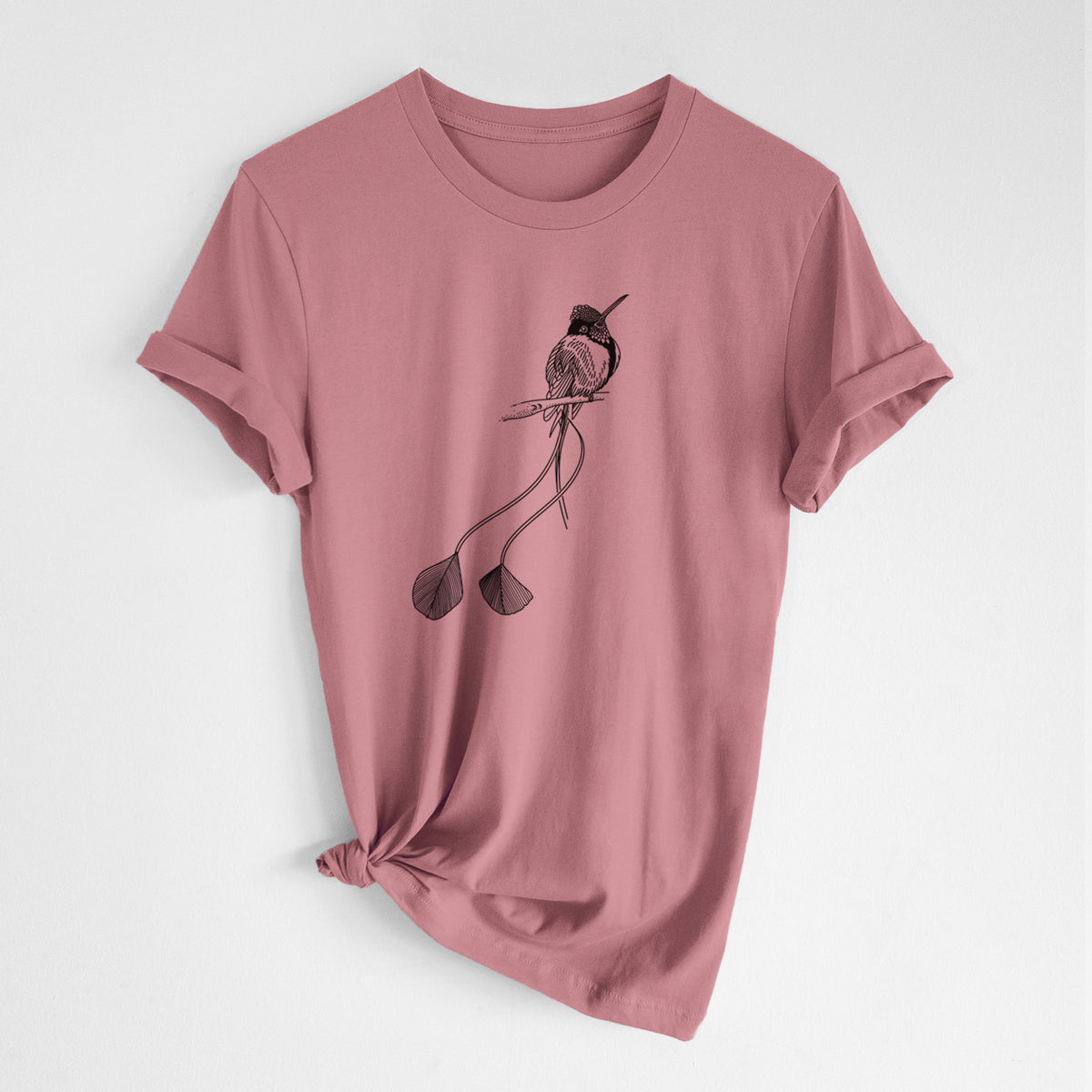 Mauve pink lightweight cotton t-shirt laid flat with the sleeves rolled, printed with a black ink illustration of a marvelous spatuletail hummingbird perched, with its two long racket-tipped tail feathers.