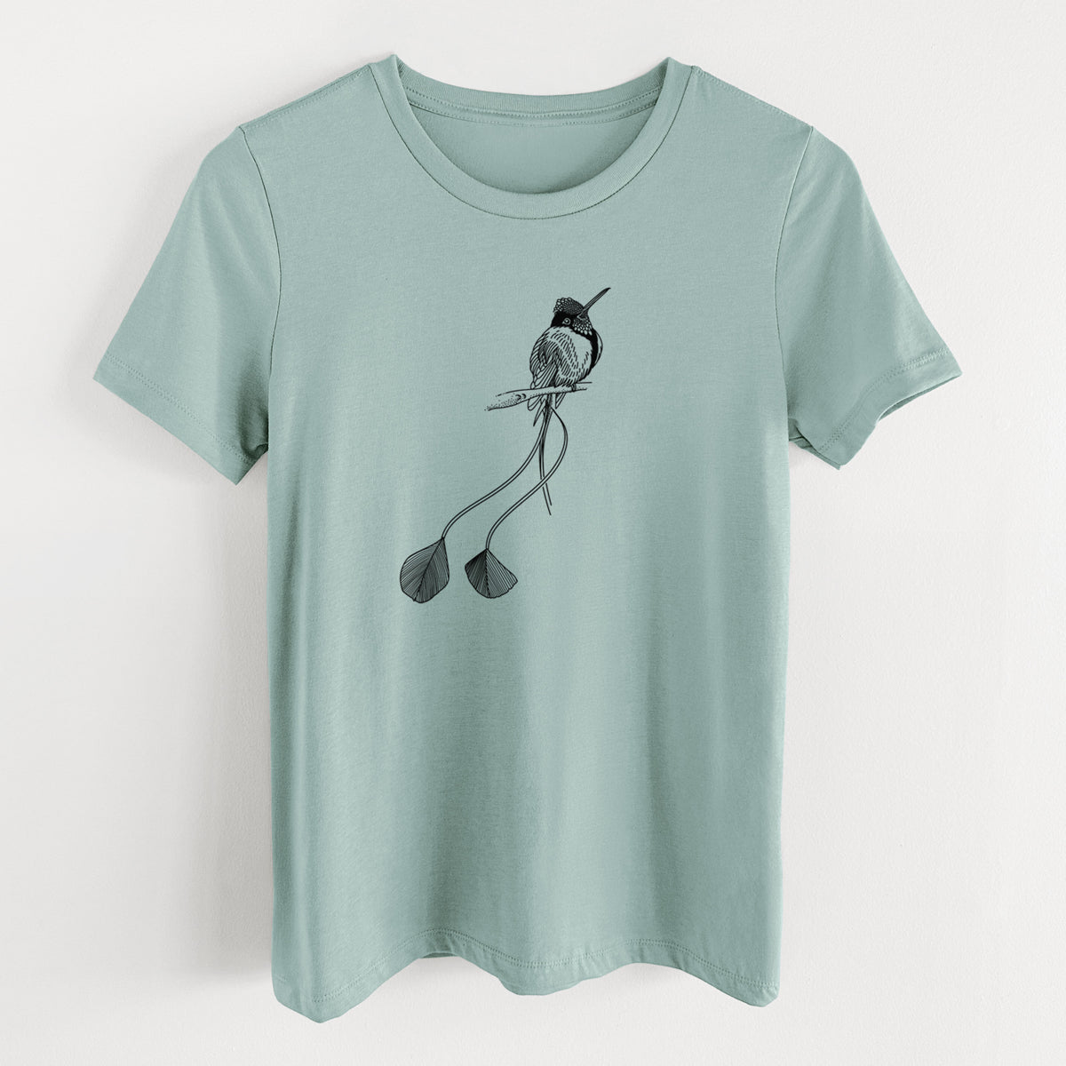 Dusty blue women's relaxed fit cotton t-shirt laid flat, printed with a black ink illustration of a marvelous spatuletail hummingbird perched, with its two long racket-tipped tail feathers.