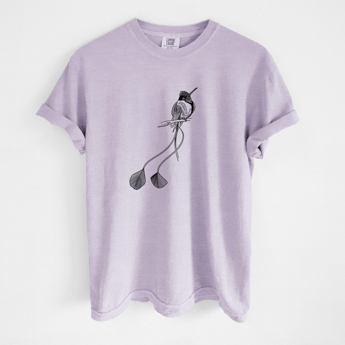 Orchid purple Comfort Colors t-shirt laid flat, printed with a black ink illustration of a marvelous spatuletail hummingbird perched, with its two long racket-tipped tail feathers.