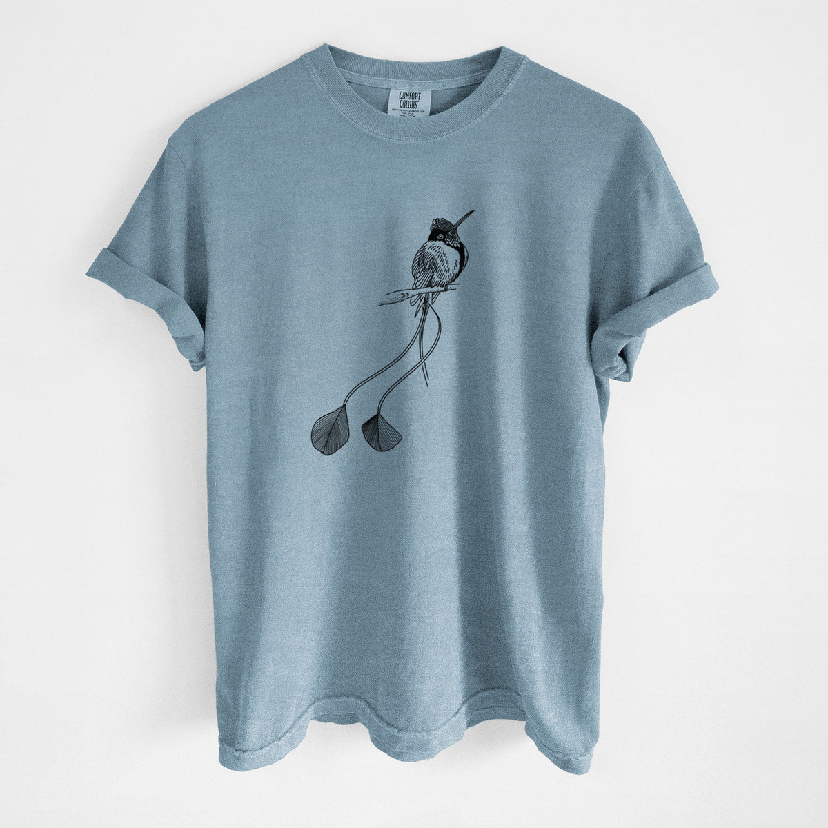 Steel blue Comfort Colors t-shirt laid flat, printed with a black ink illustration of a marvelous spatuletail hummingbird perched, with its two long racket-tipped tail feathers.